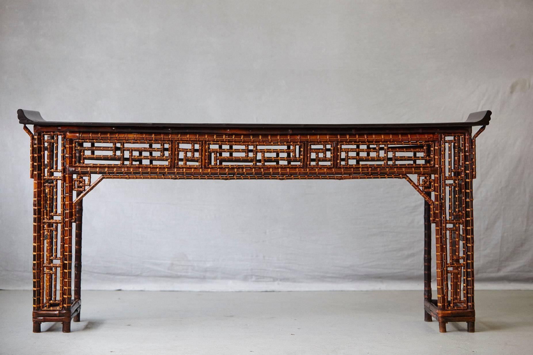 Chinese bamboo and lacquered wood altar table with geometric fretwork design made of bamboo and a black lacquered top, circa 1910s.
Measurements: H 33, at the bended corners height is 35 x W 73 x D 15.5
Purchased from a well-known Asian antique