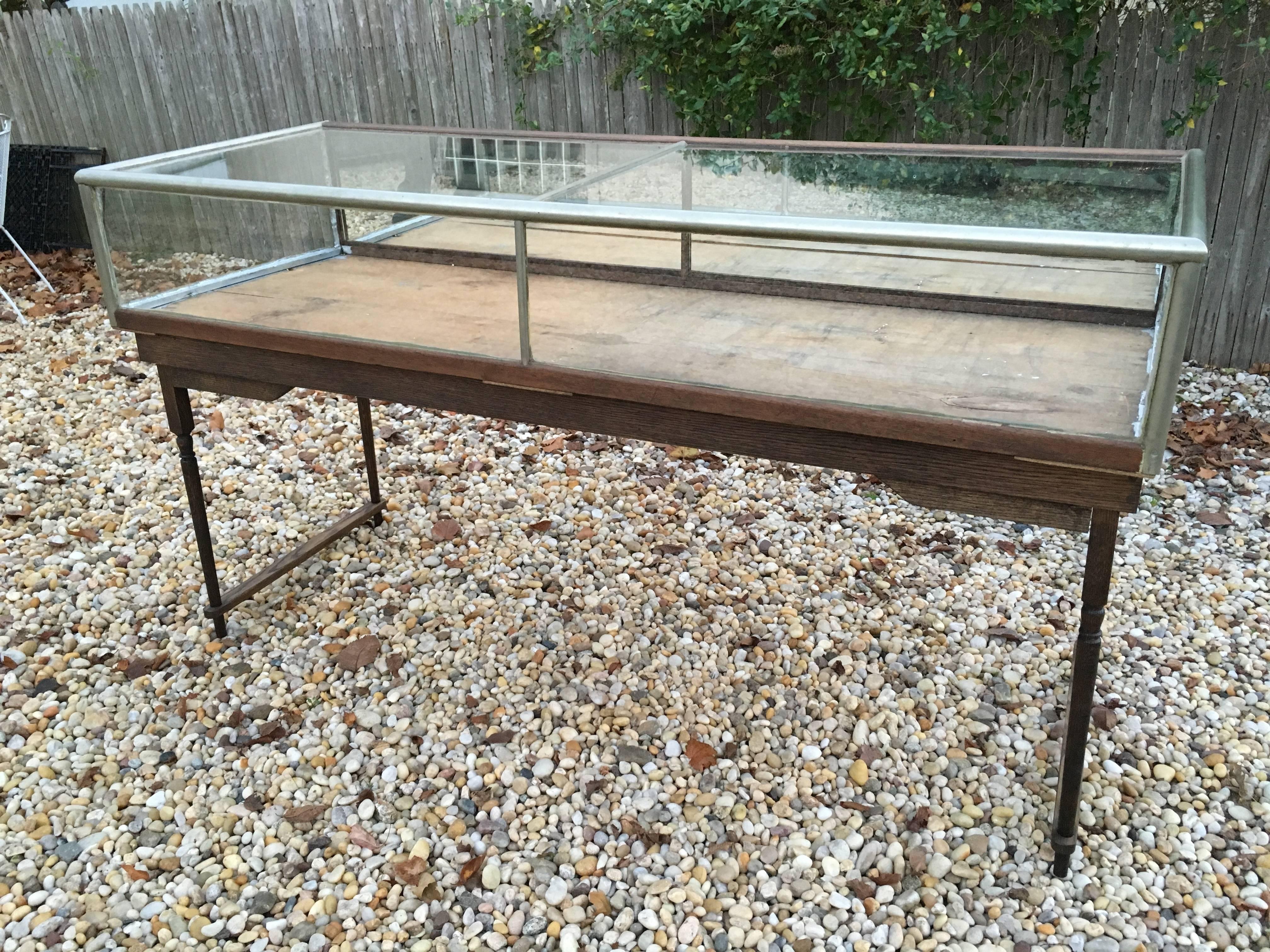 Turn of the century nickel display case on a custom oak frame with oak support stretchers.