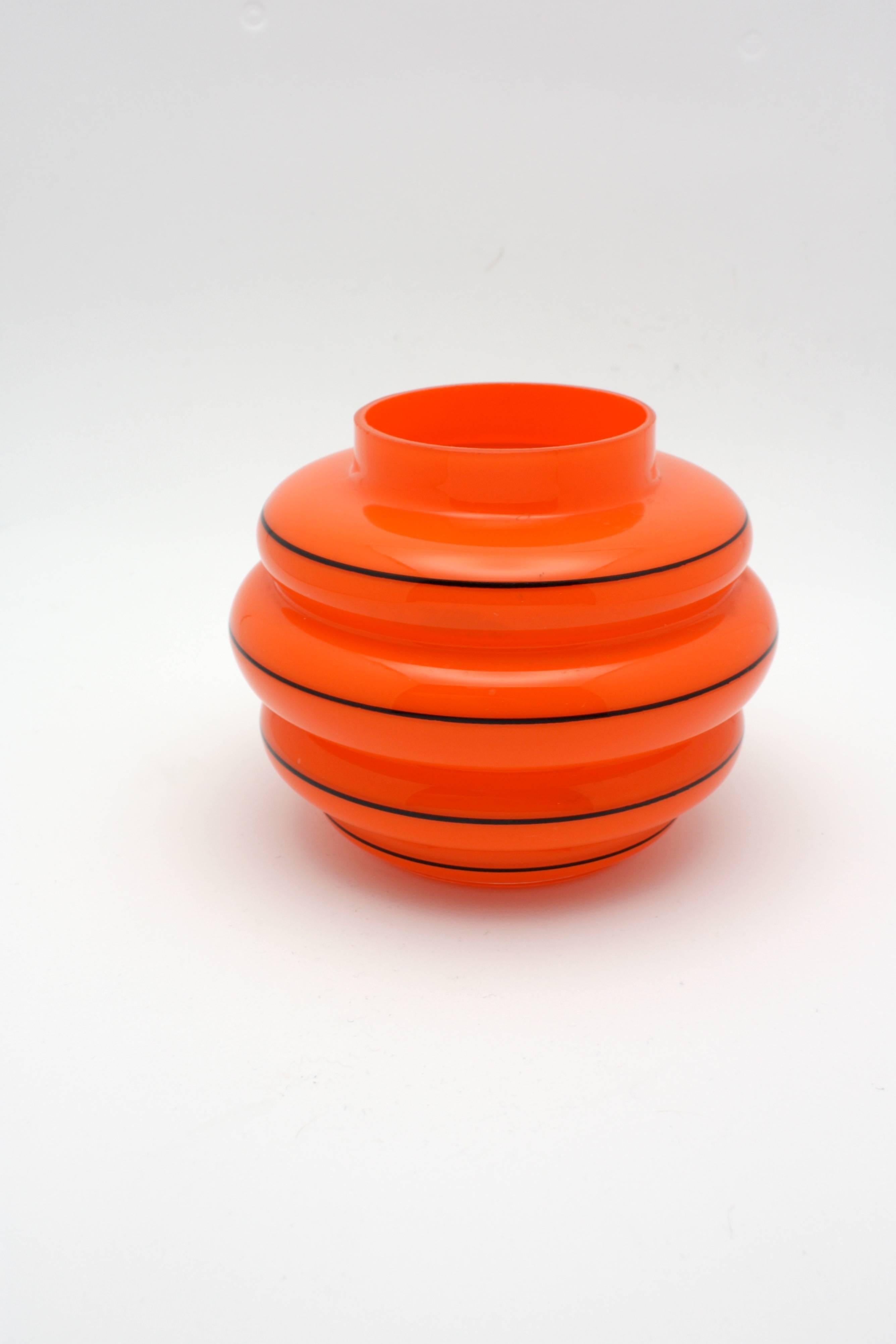 Michael Powolny (Austrian, 1871-1954), a Loetz orange cased glass vase is ribbed inform with horizontal black enamel banding throughout.
 