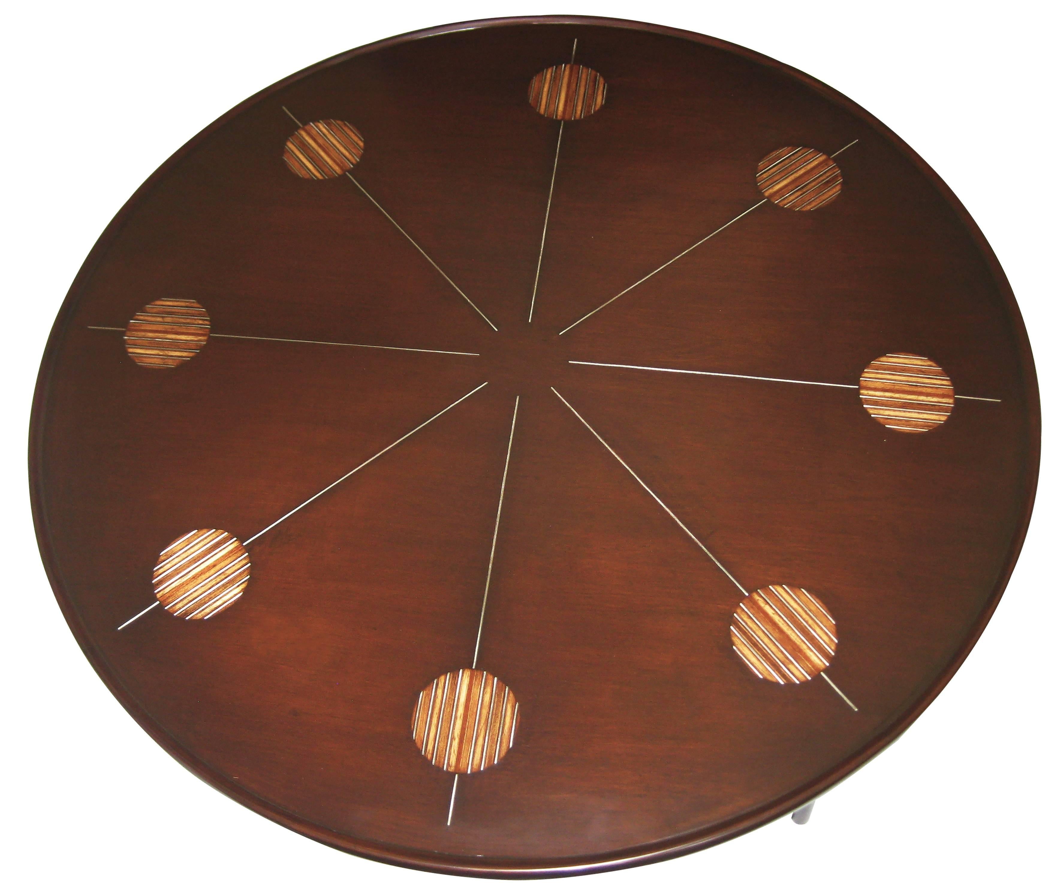 Center table of mahogany embellished with unusual and quite exquisite tropical-wood-and-brass marquetry.