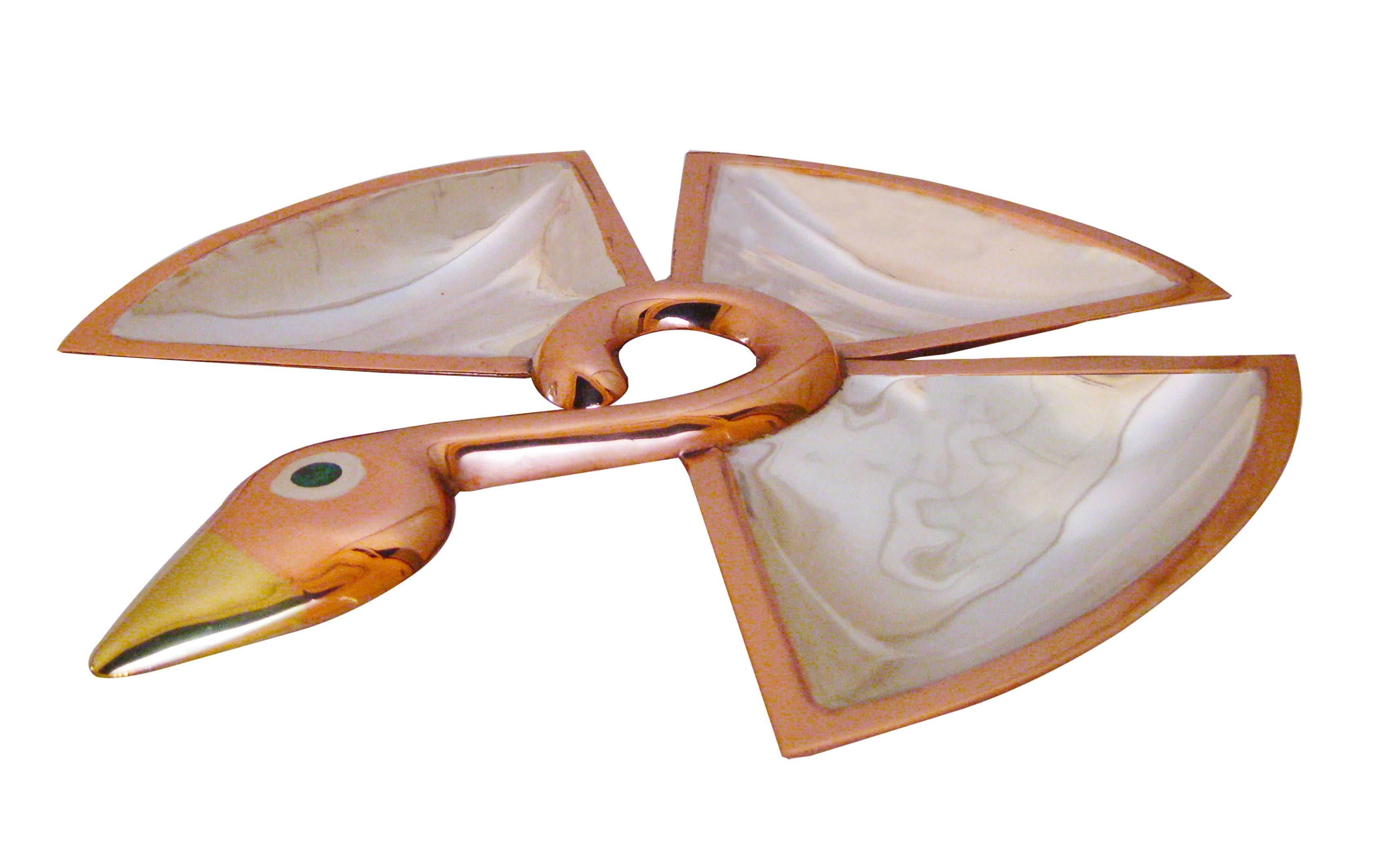 Iconic sculptural platter in the shape of a copper bird with an eye of jade and a brass beak. The three compartmentalized sections are melded in silver. Signed Los Castillo, Taxco, hand-wrought. In pristine condition.

Antonio Castillo began his