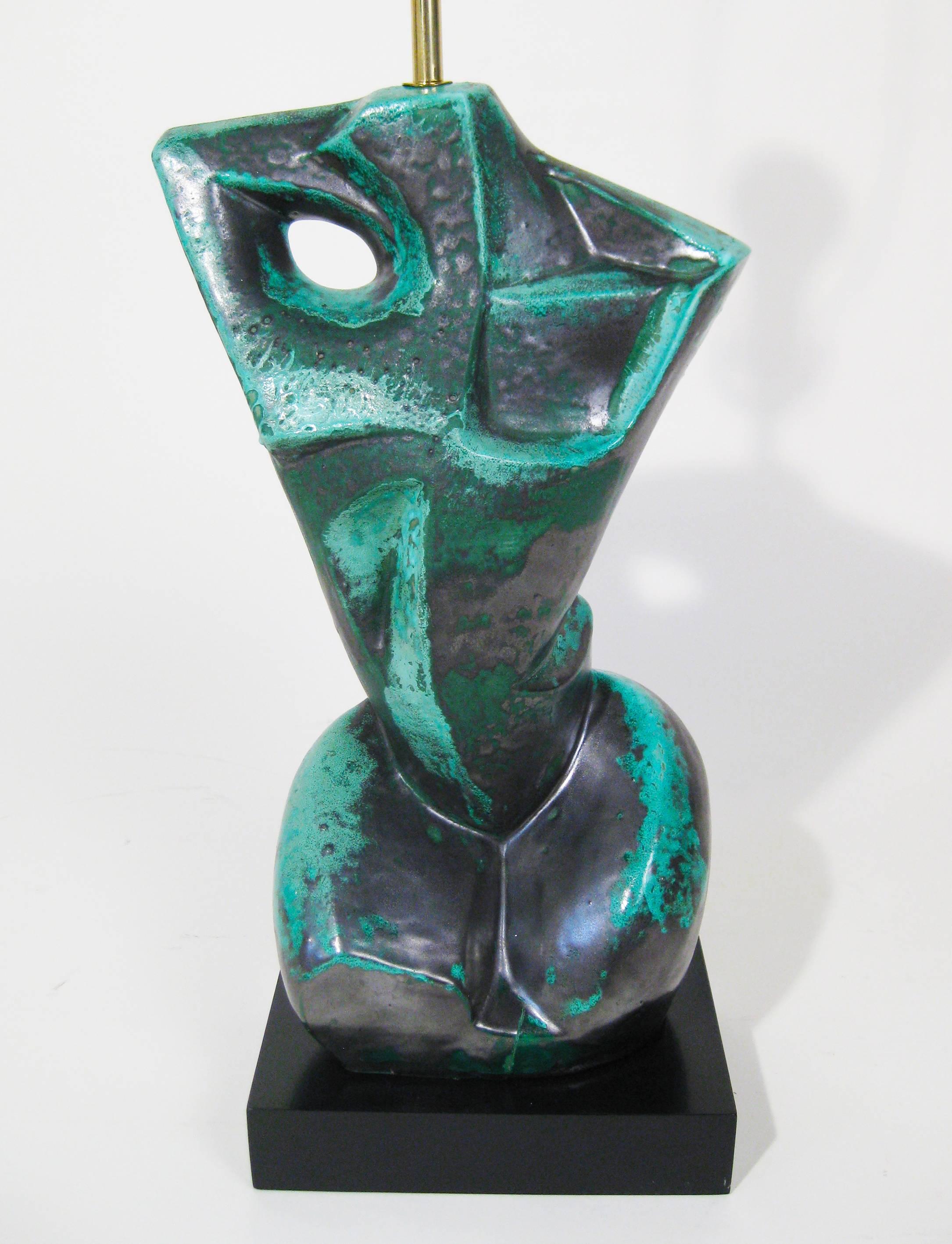 Striking sculptural lamp of a feminine torso, glazed green with graphite hues. Mounted on a black-lacquered wooden base and topped with a black satin shade with gold interior. Lovely and in perfect condition.