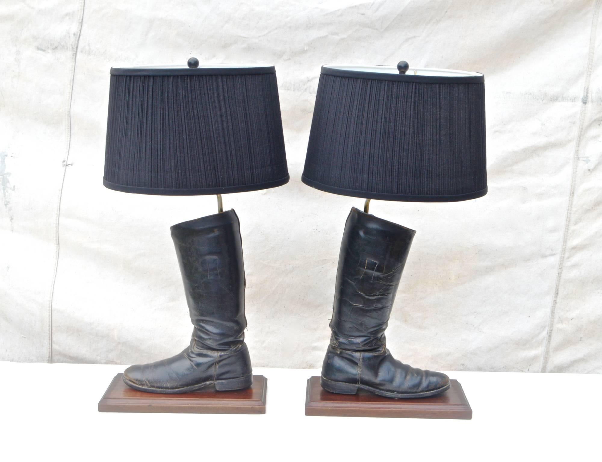 A finely made pair of English leather riding boots mounted as lamps. Well worn with scuffs , scrapes and natural patina, they sit atop solid oak bases which have long been varnished many times over giving them a natural lustre and gentle shine. Both