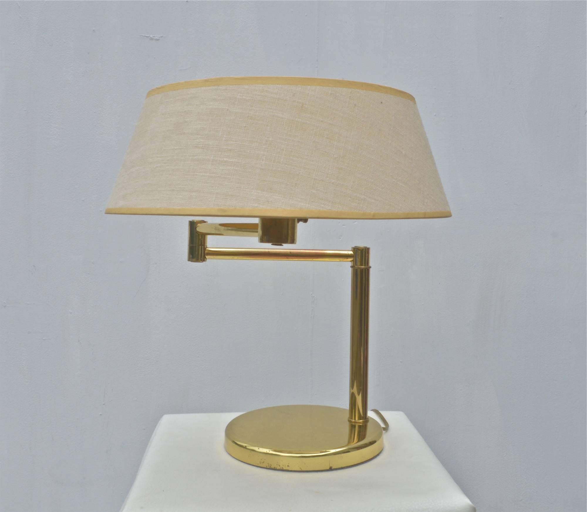 Iconic and classic brass swing arm desk lamp by Walter Von Nessen. Original oatmeal linen shade and white metal mesh diffuser included. Labelled as pictured. Brass finish shows wear throughout.