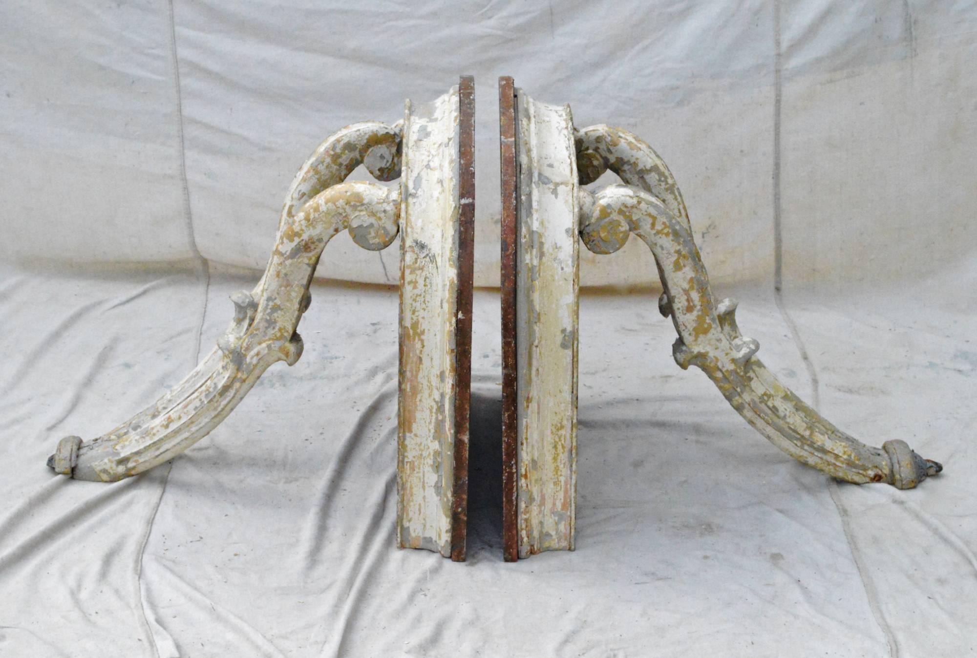 Fantastic pair of wall-mounted consoles with faux marble "D" shaped tops resting on molded demilune shaped aprons and ending with curving, Baroque scrolled legs. Late 19th century.
