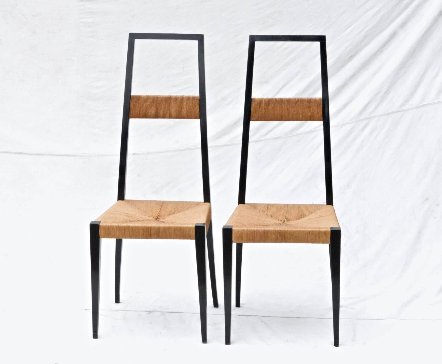 A striking pair of ebonized high back side chairs in the distinct style and manner of Gio Ponti. Attention to detail and smart design are obviously hallmarks of these beautifully made chairs. Original black finish shows attractive wear. Rush is in