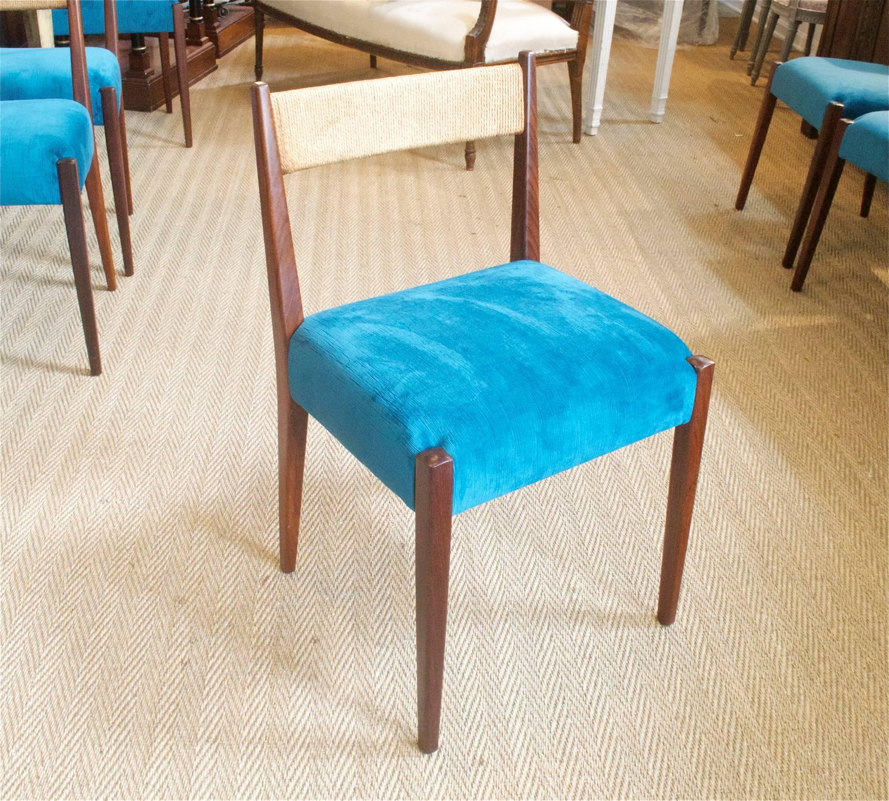 A set of Danish modern dining chairs of teak dressed up in a zappy peacock velvet. The early 1980s chairs are unsigned and retain the original Danish cord up top on the backs. Chairs have just been reconditioned and reupholstered and are in showroom