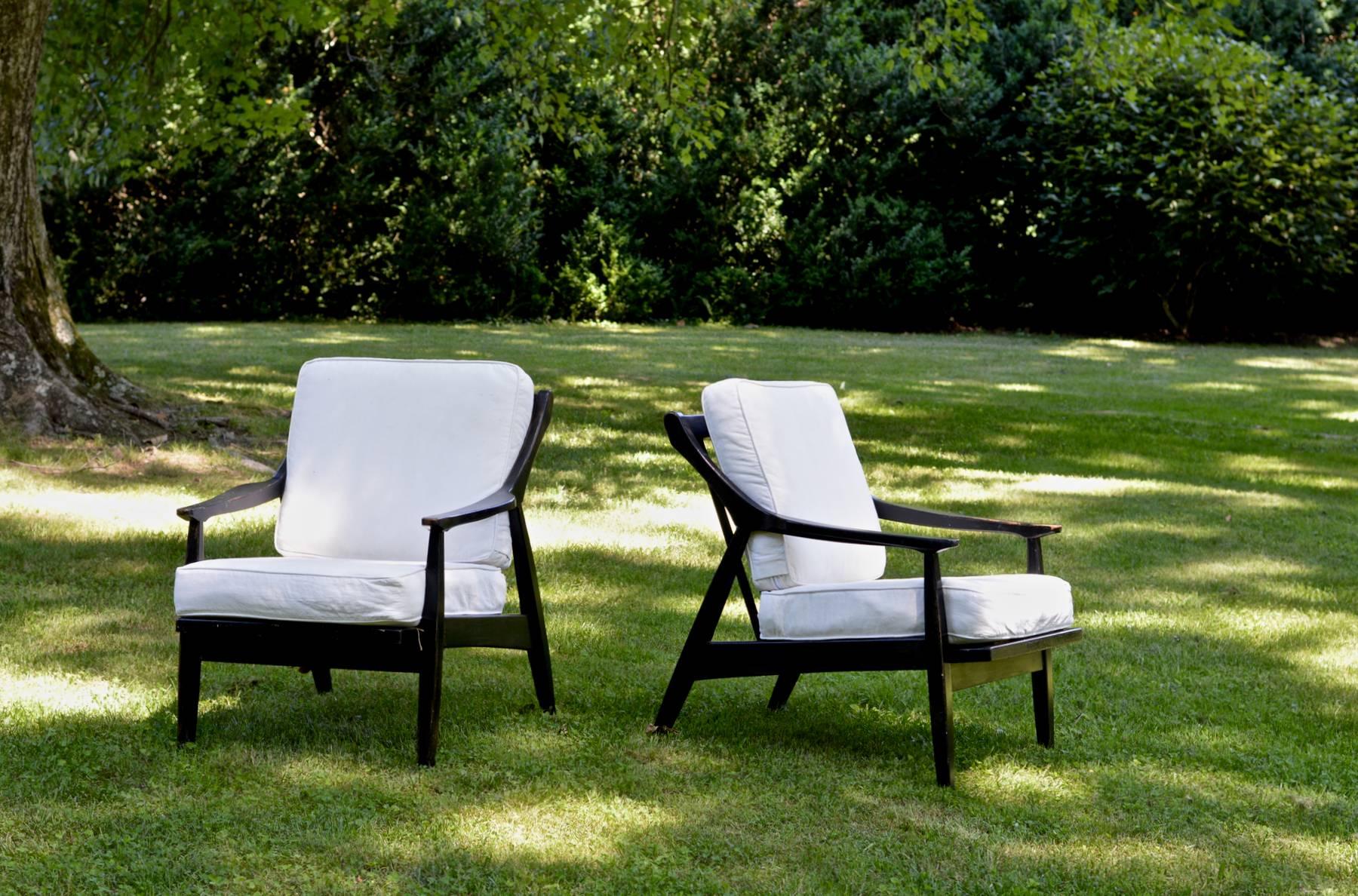 A pair of vintage lounge chairs in the Scandinavian Modern taste. The comfortable and smartly designed frames were ebonized in 2002. The cushions upholstered in a supple white duck in 2012 and gently used in a painter's studio. The look is both