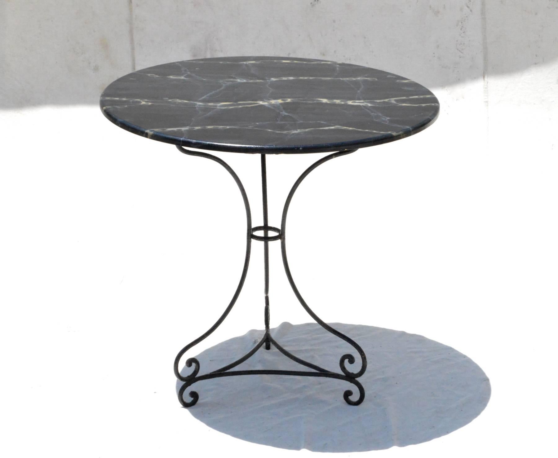 Fantastic round bistro table having faux marble wood top resting on a hand-wrought iron tripod base. Bring Classic garden looks inside as a small breakfast nook table or use as a center table within a smaller interior. 

 