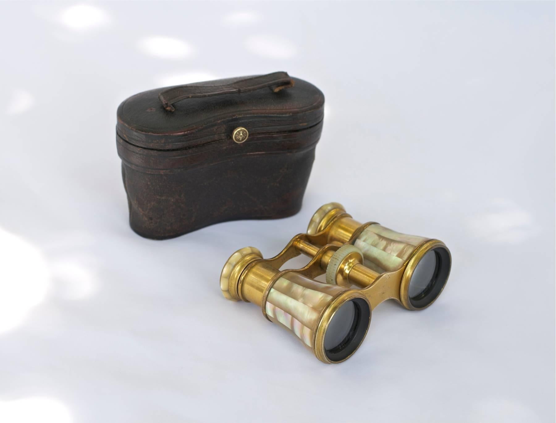 High quality pair of French opera glasses of brass, gilt bronze and mother-of-pearl. Original leather case. Case is lined with a rust colored velvet with gold stitching as an accent. Lenses are very clean throughout and are 100 percent functional.
