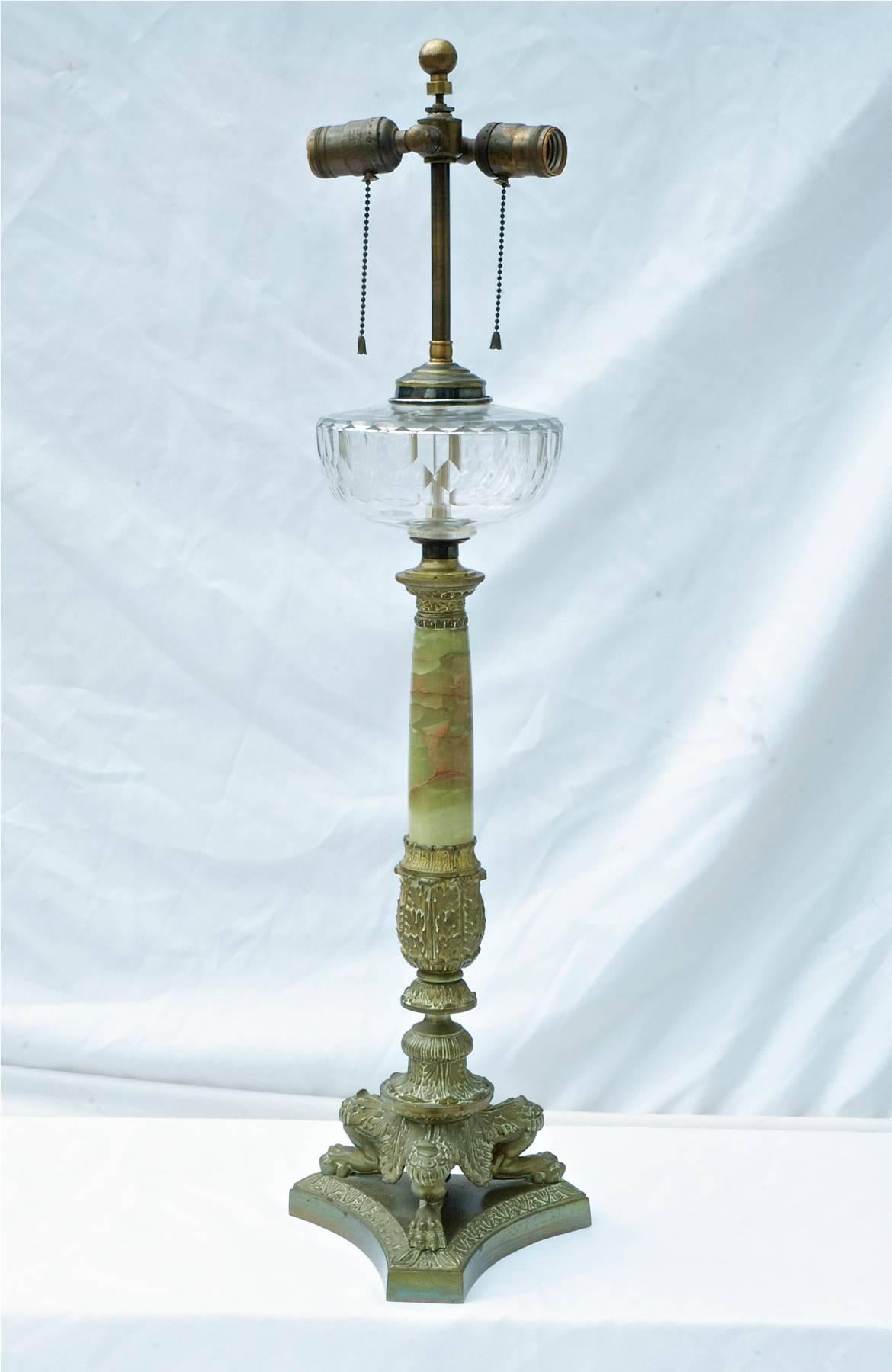 A single French Empire table lamp converted from original oil lantern. Comprised of green onyx , brass and bronze works the light possesses scale and stature that will work well in any traditional interior.
Lamp sells and ships without the pictured