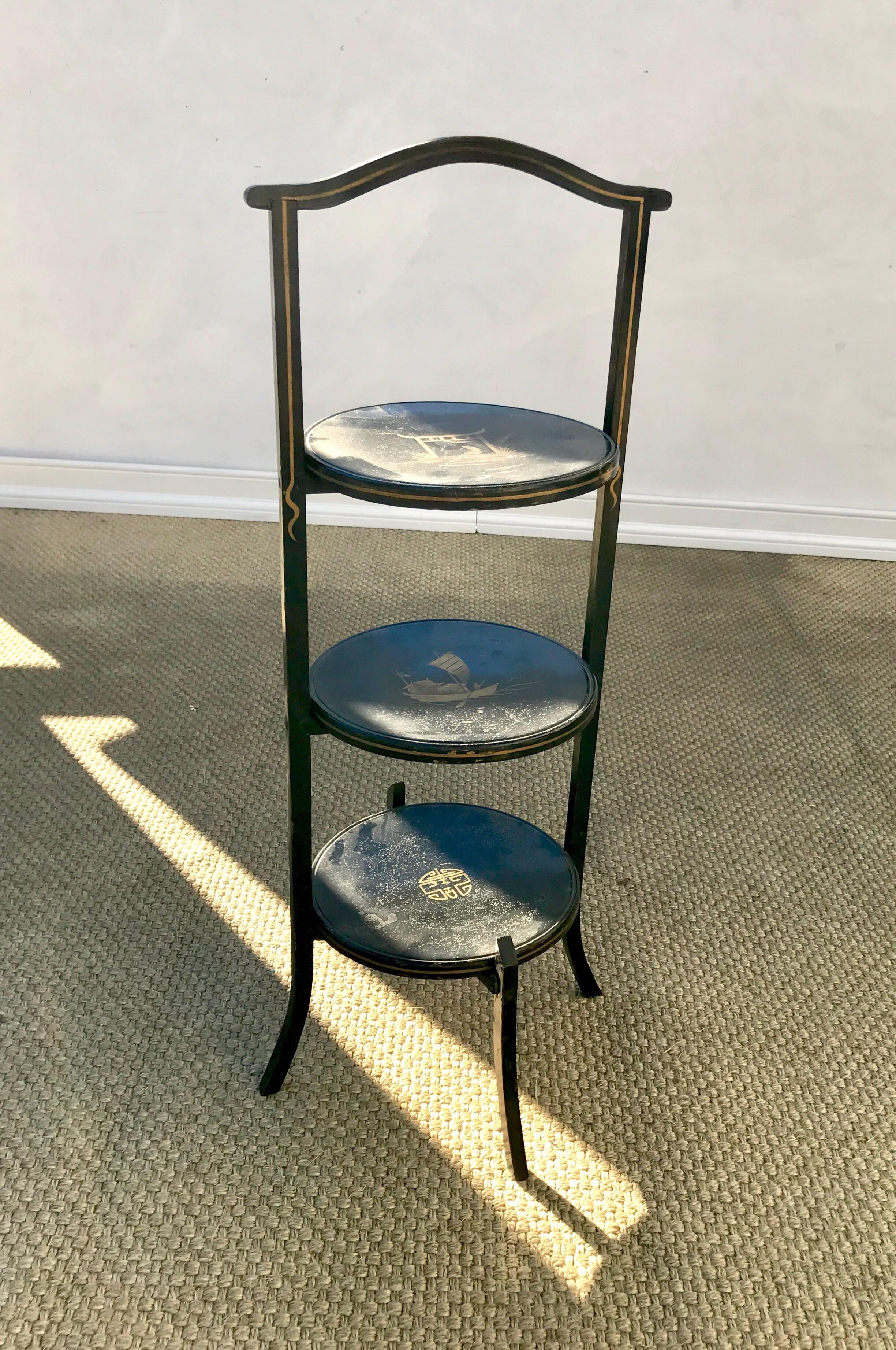 An ebonized three-tier chinoiserie painted muffin stand. The petite serving table is English was purchased outside of London by John Rosselli and Associates for the wonderful lady I recently purchased it from. The paint work is lovely and gives the