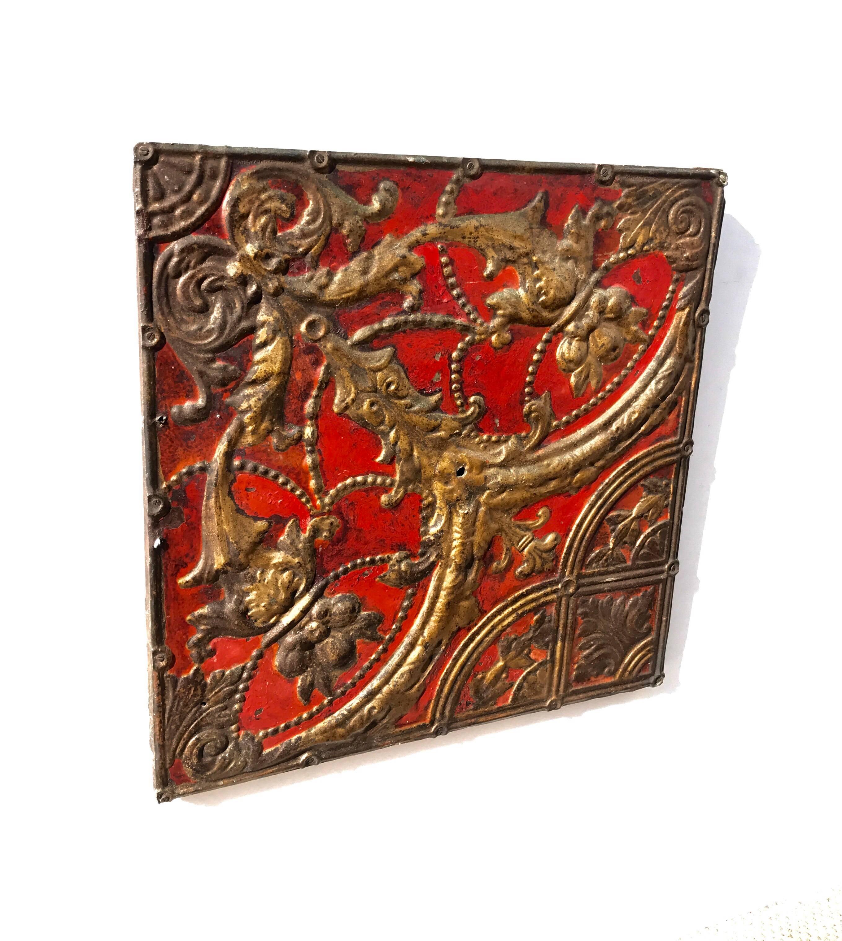 A stunning 19th century tin ceiling tile with hand-hammered beading accents and vibrant yet warm old red and gold painted surface. A wonderful hanging decorative object that will add character and patina to any space.