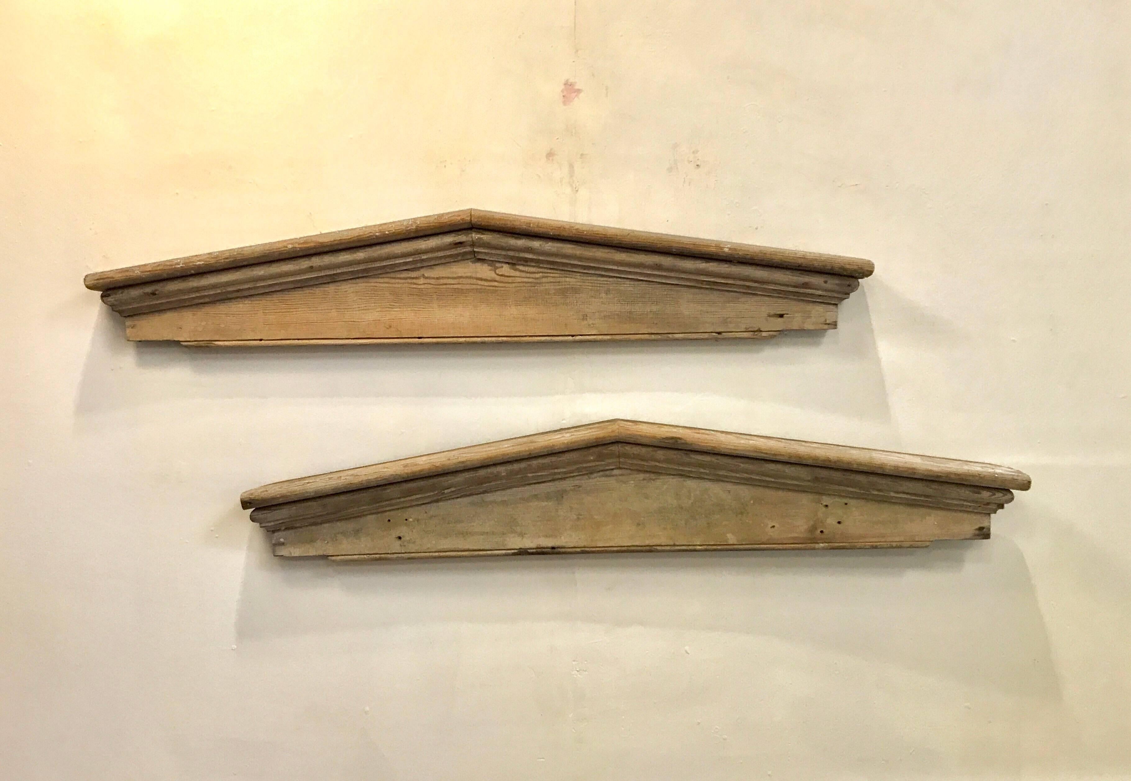 A rustic pair of architectural door pediments of pine. Both have an attractive and old whitewash about them. Killer decorative accents here. 