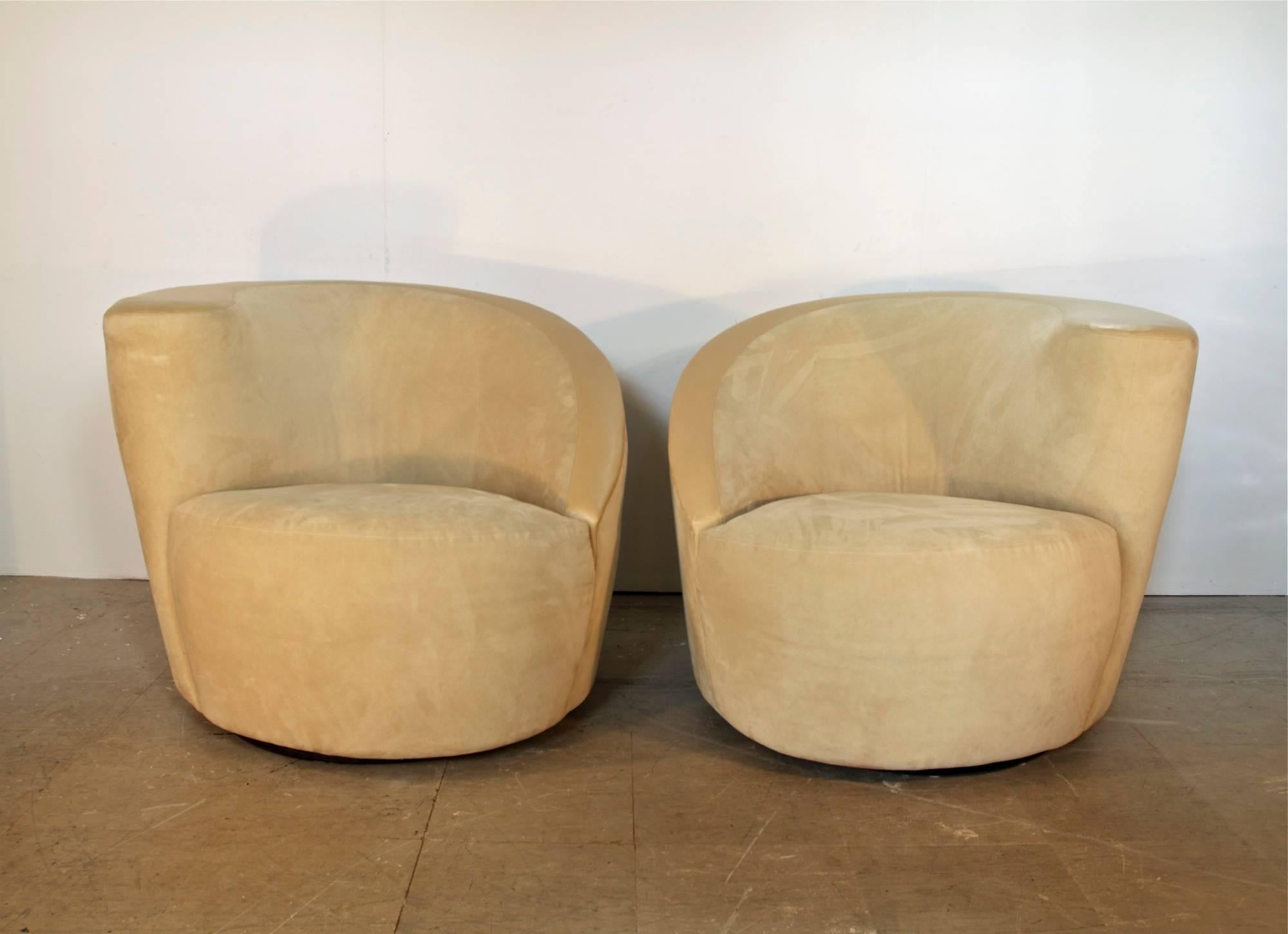 Pair of nautilus lounge chairs by Vladimir Kagan for Directional, circa late 1980s. The sculptural frames are upholstered in a plush cream microsuede which makes for very comfortable seating. The chair design exhibits smart spring loaded bases which
