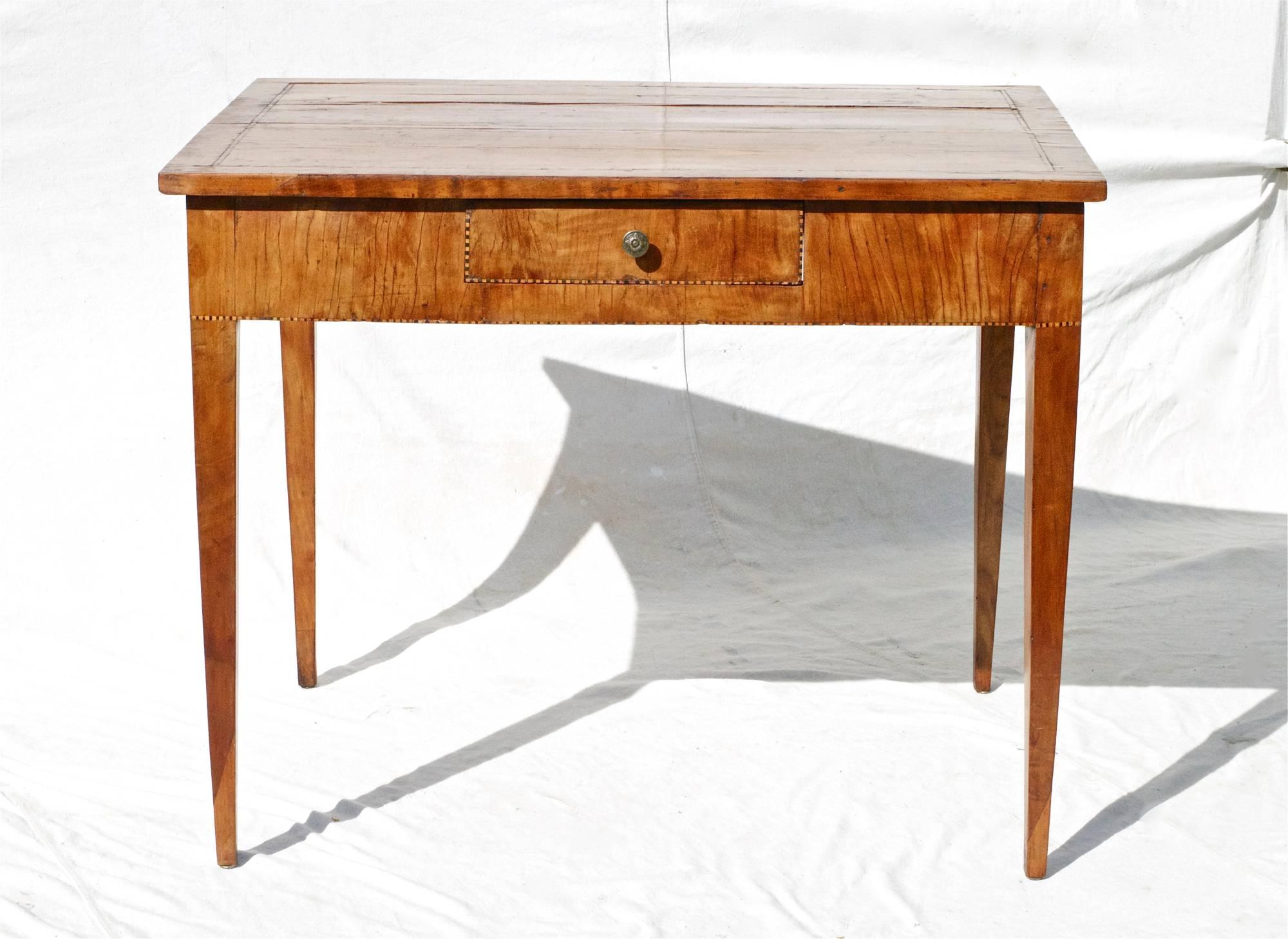 Late 18th century Italian writing or centre table with stunning good looks. The rectangular top shows many repairs along the way and is gently supported by tapering legs of a graceful proportion. The table is outlined throughout with a simple
