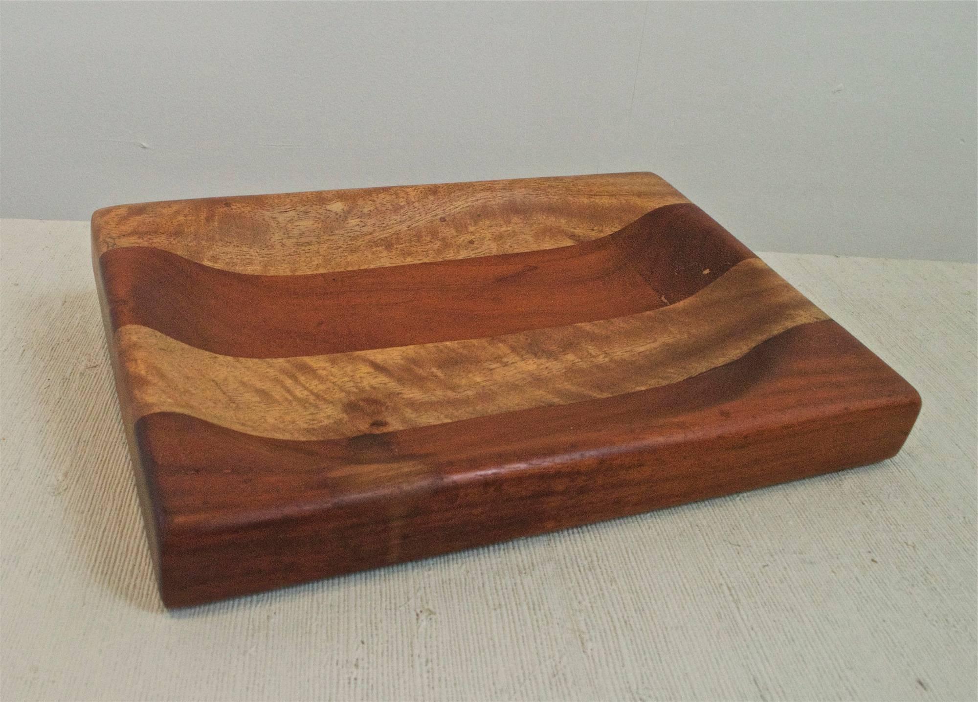 A shallow catchall bowl of teak and mango woods. The artisan made piece is skilfully joined and turned and is a work of very high craftsmanship.