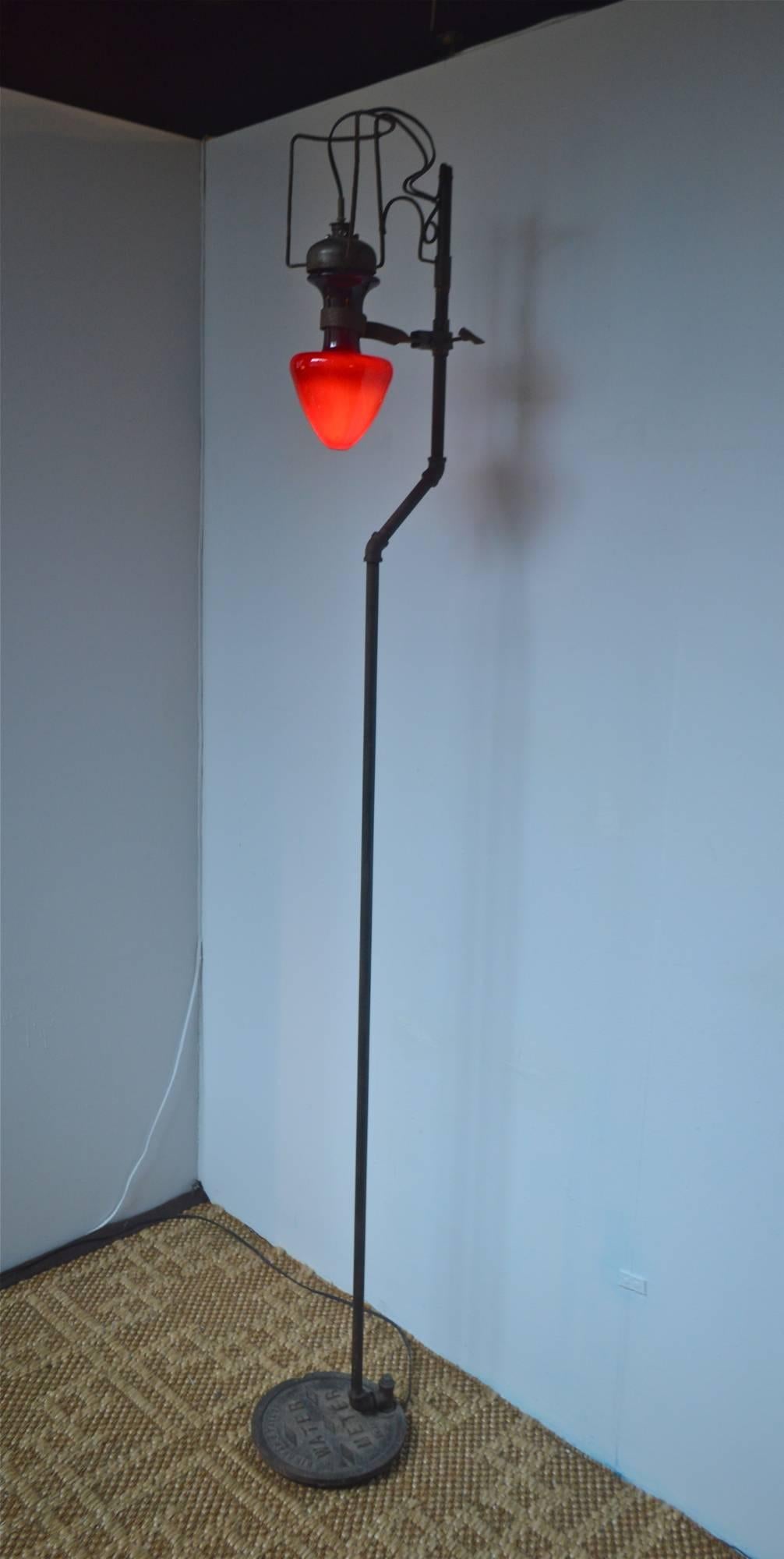 A very unique floor lamp having Industrial and Steampunk style. The tall light was created with youthful passion by ceramic artist / musician Eli Simon around 2001-2002. Composed of found metal elements the spartan and futuristic lamp is juxtaposed