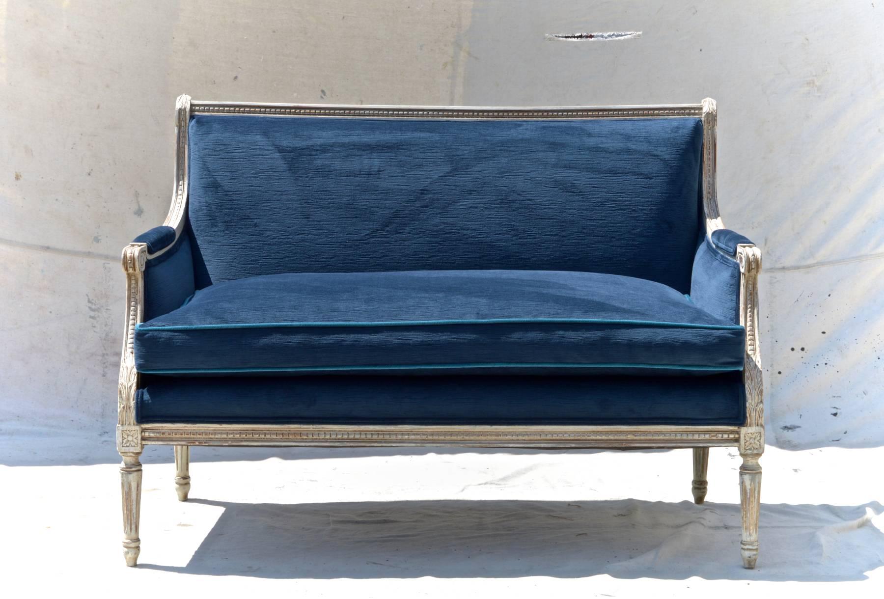 A stunning pair of Louis XVI style settees in navy velvet. Custom finished grey frames support plush and reconditioned single long down cushions on each love seat. Cushions are outfitted with a subtle contrasting pipping in peacock velvet.
The look