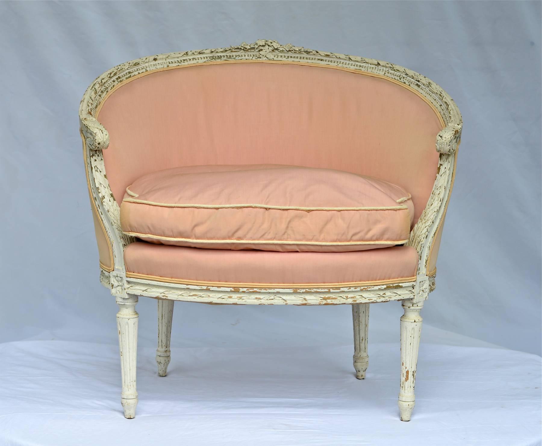 A charming late 19th Century painted Corneille Canapé in the Louis XVI style. The old chalky white paint surface shows chips and great character throughout the frames surface. The blush pink silk shows wear and sun fading throughout. The small