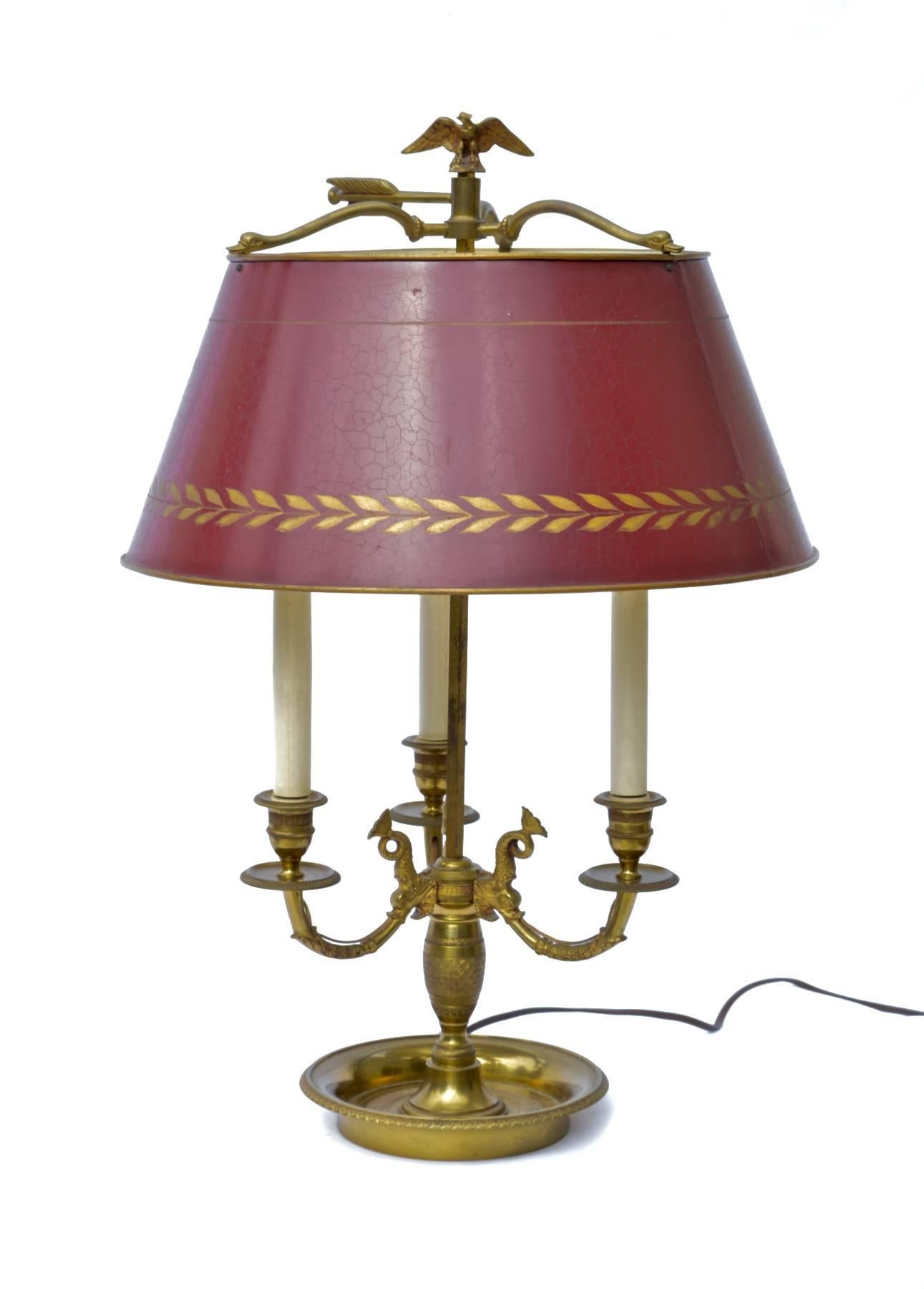 A Classic bouillotte table lamp in the French Empire taste. Vintage 1950s, the stylish light will perform well in any space in which it is employed. Hand-painted deep red tole' shade.