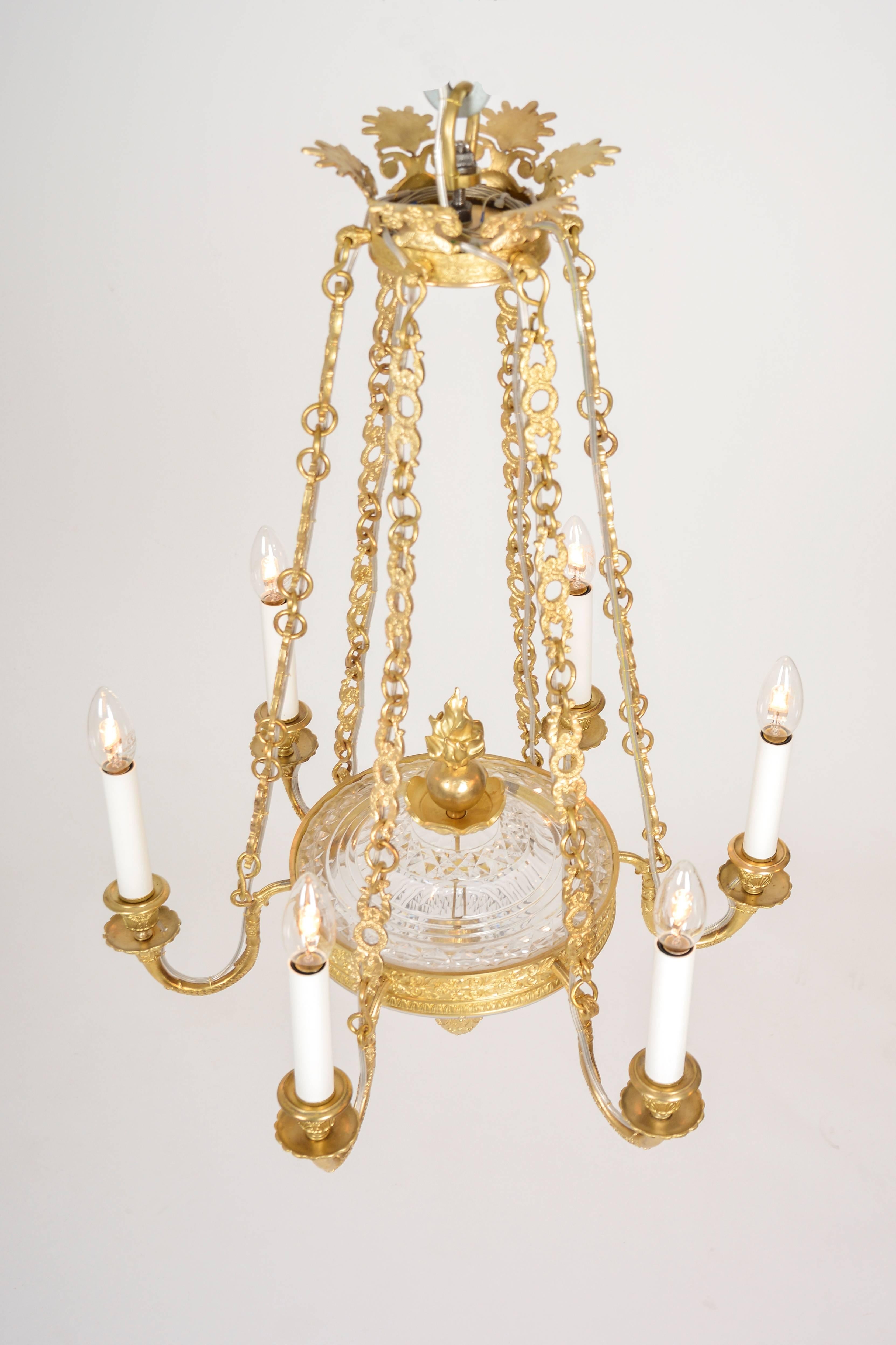 Small chandelier of brass and hand cut crystal. Brass frame holds elaborately cut crystal bowls. Both top and bottom bowls are cut with brilliant and facet cut. Brass parts are exquisitely cast and refined to a rare depth and perfection. Its top and