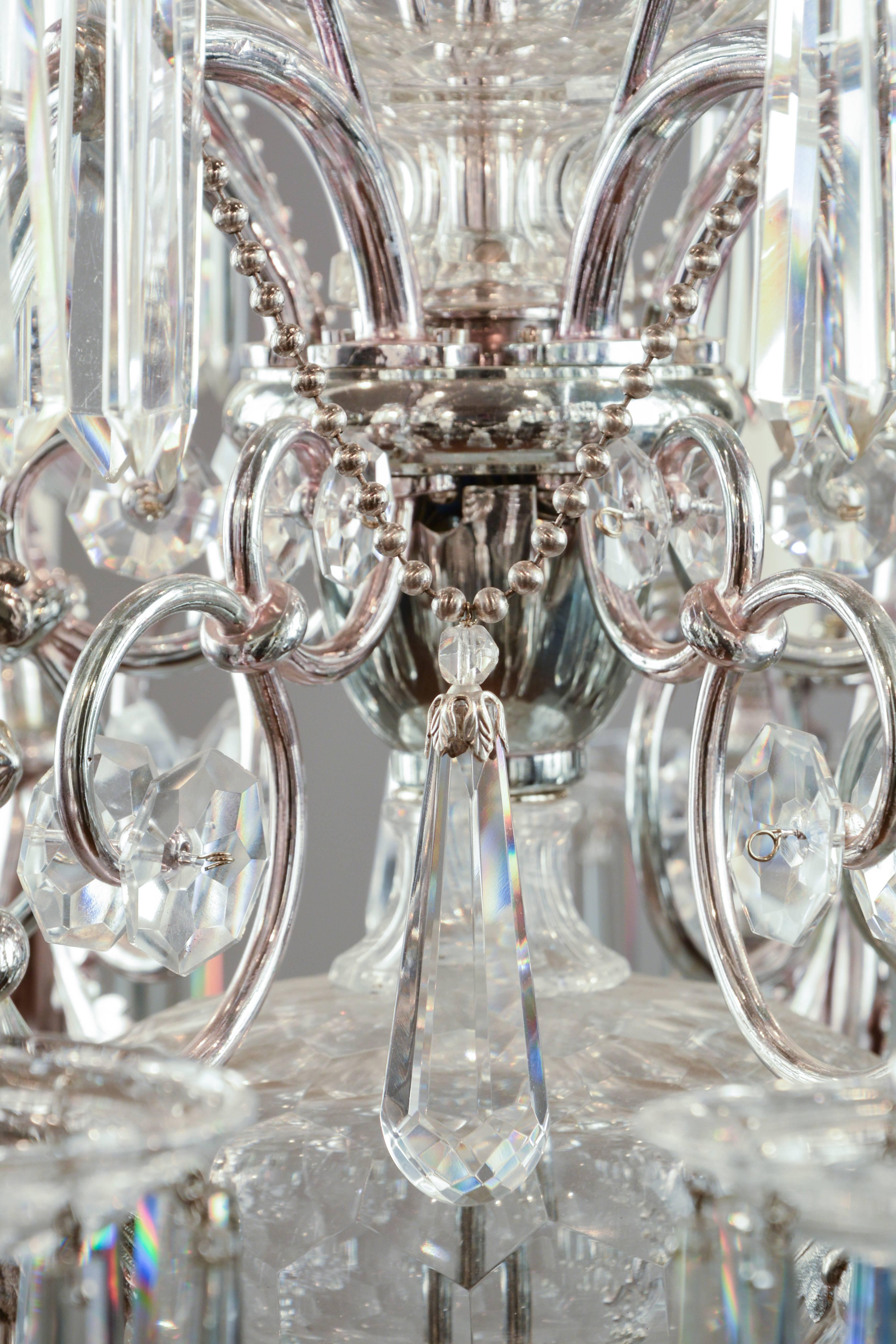 Typical Lobmeyr chandelier from circa 1880 for 18 candle bulbs.
Elaborate brass frame with lovingly refined cast applications. Masterly cut and polished crystal parts along column. The drop catchers are of the Lobmeyr signature type with the
