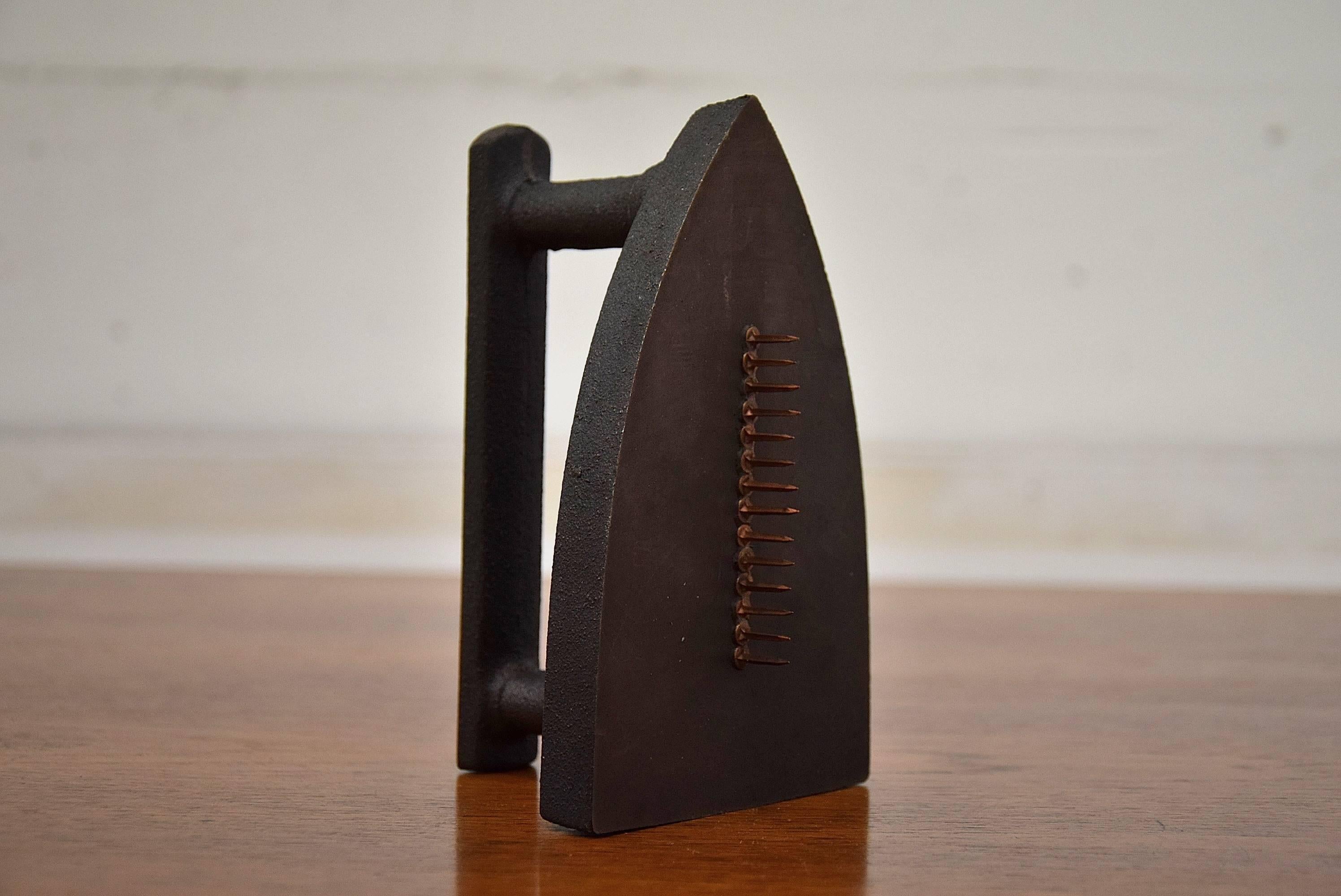 Gift è un tipico prodotto dell'umorismo a doppio taglio di Man Ray. Le sue implicazioni sadiche non hanno bisogno di essere sottolineate. Il suo aspetto erotico è rivelato dall'osservazione di Man Ray: 'Con essa si può strappare un vestito a