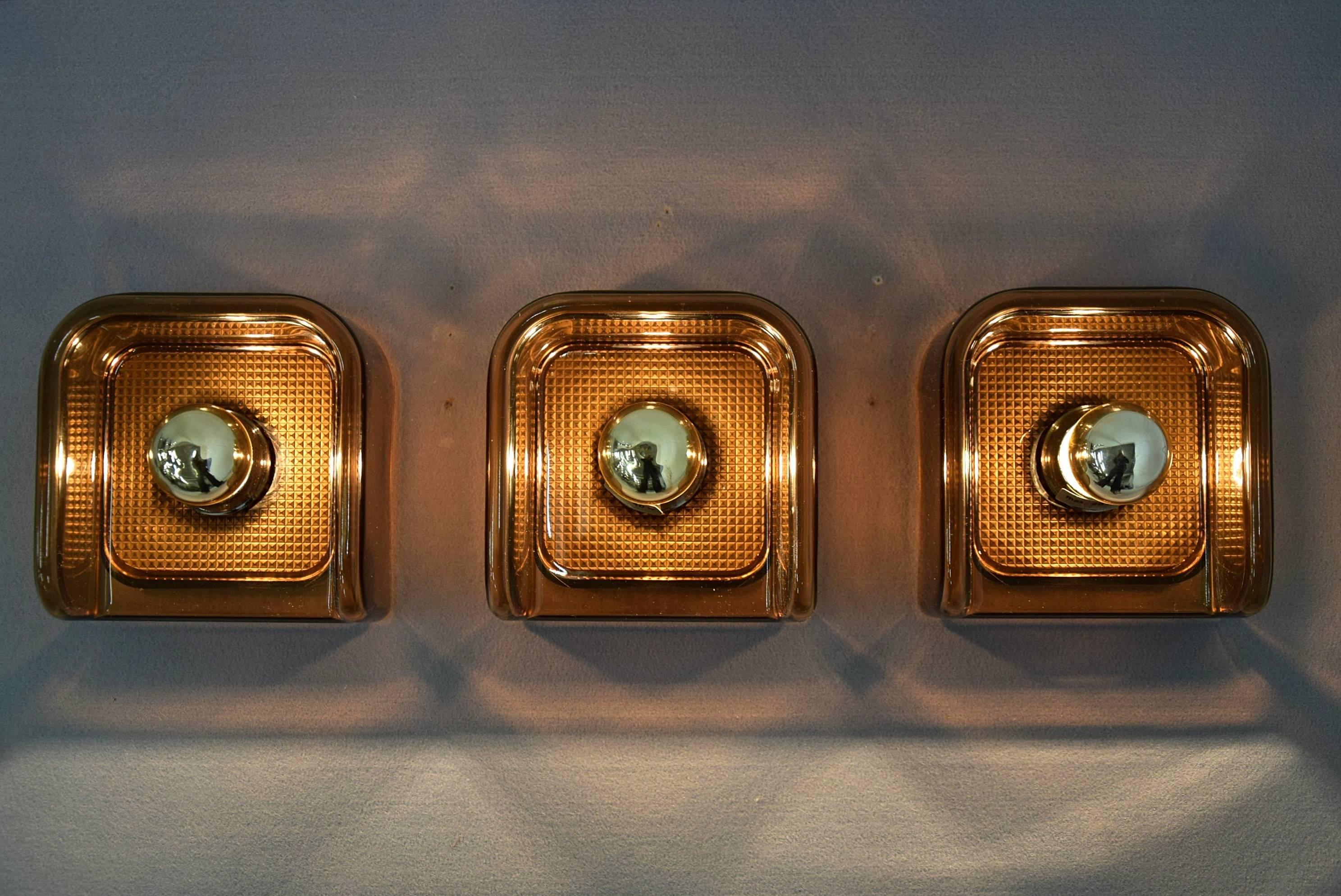 Three Brown new old stock Guzzini sconces from the 1970s. 

40 pieces available new in box.

Measurements: H.15 x W.15 x D.9 cm.

Price is for 3 pcs.