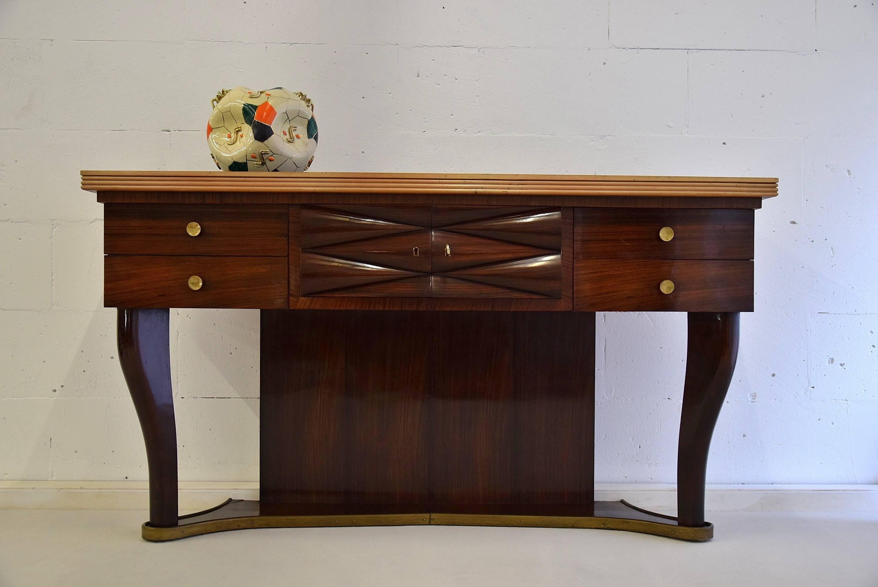 Stylish and elegant mid-century Jatoba sideboard by Osvaldo Borsani.
A beautiful work of art from the 1940s.
Made of Jatoba, a black glass top and brass details.
The sideboard will be shipped in a custom made wooden crate. Cost of insured transport