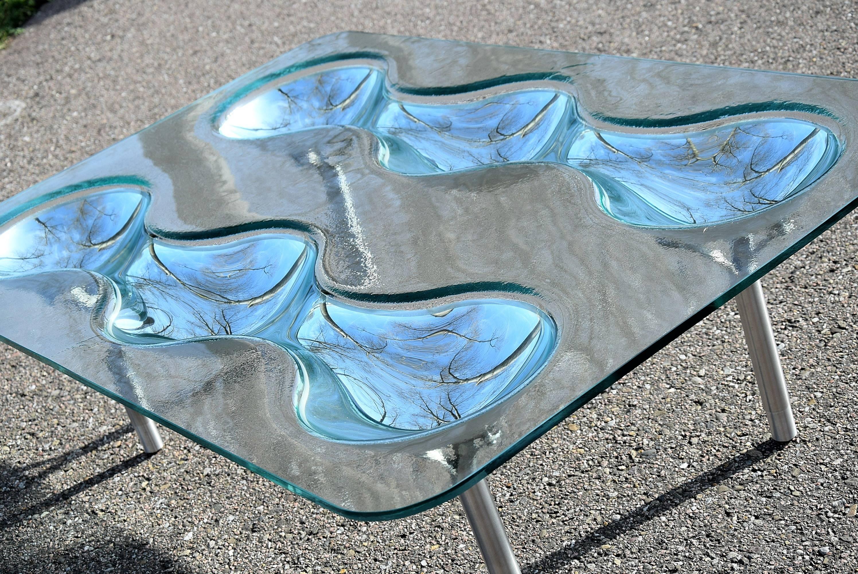 Coffee table Konx by Rona Arad
Konx is a unique coffee table in 10 mm-thick fused glass with hollowed-out back-silvered parts. Features include intriguing visual quality and adjustable feet in glazed stainless steel produced in the early 1990s by