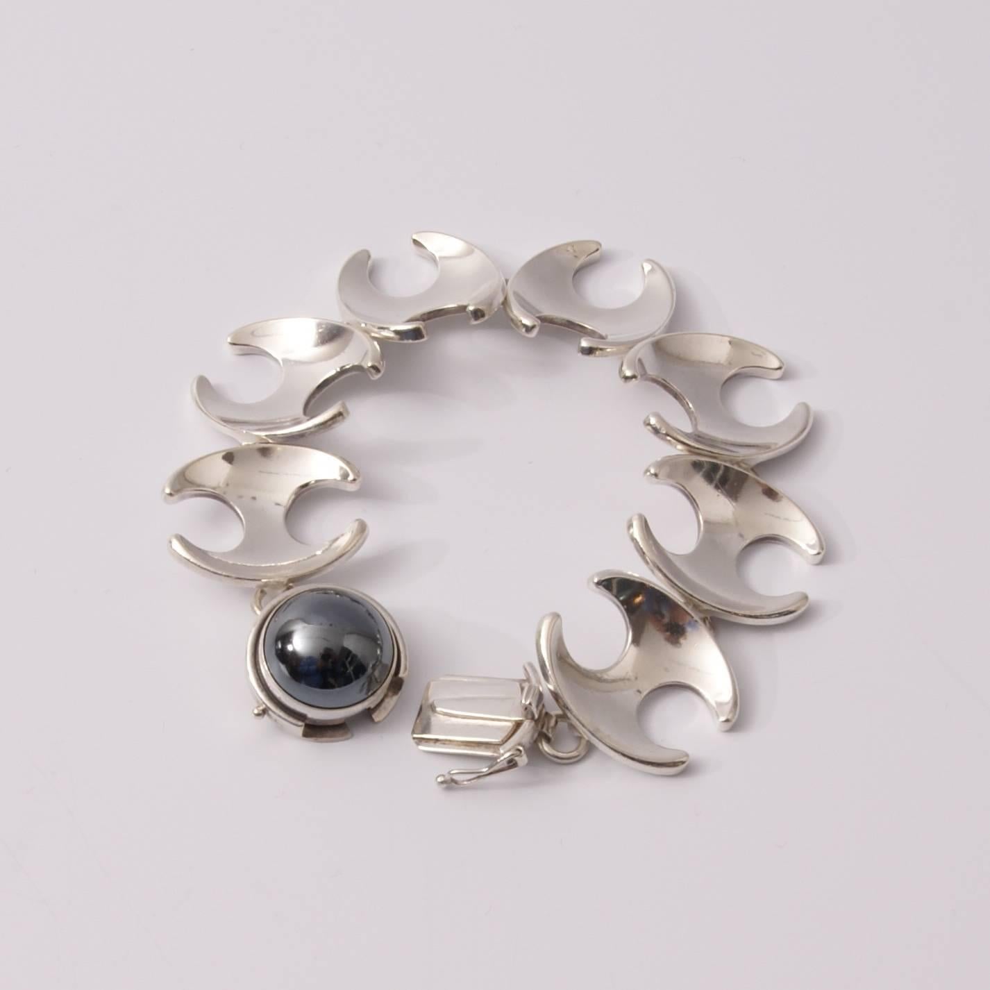 Set comprising a bracelet and a necklace n° 130 designed by Henning Koppel for Georg Jensen, 925 silver and hematite cabochon. Measures: Necklace length 40 cm (17 links) bracelet length 18.8 cm (8 links).