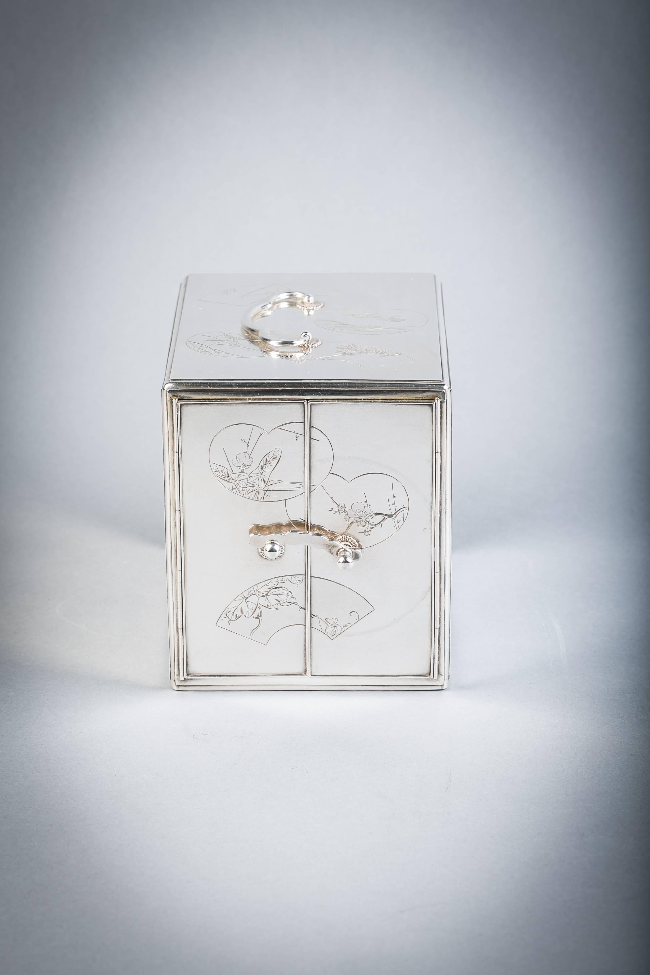 Caja armario japonesa de tres cajones de plata grabada y laca, hacia 1880.