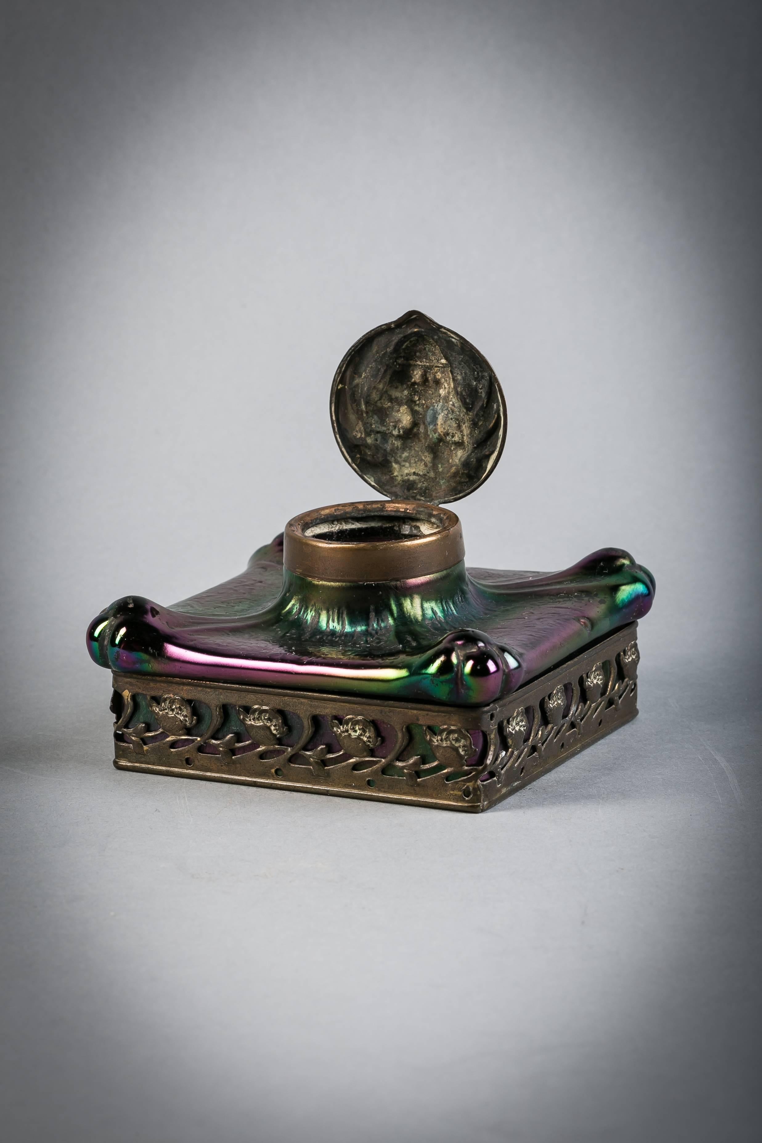 French patinated metal and iridescent glass inkwell, circa 1900.

With lions head as cover.