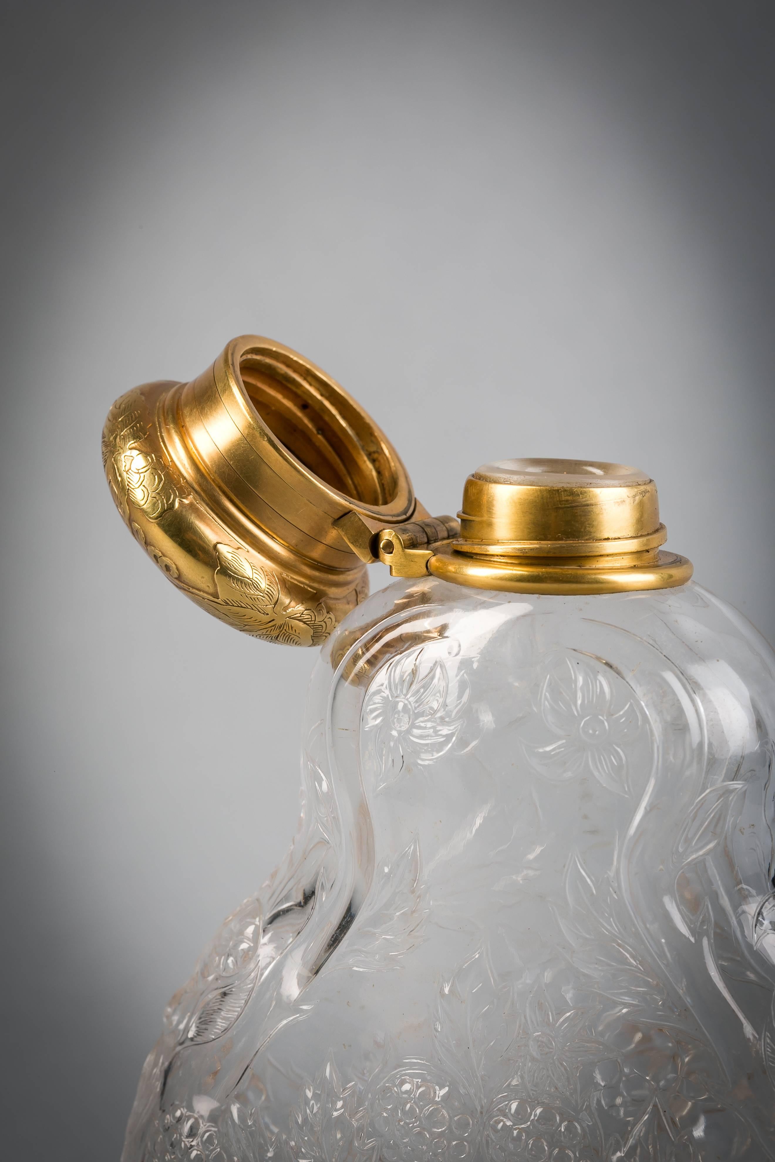 The glass with four satyr or Bacchus masks surrounded by grapes, vines and leafage, the gold cap and removable gold base, serving as a convenient cup, further engraved with grapes and vines. 

The base dated with 'C' for Charles Cook.

