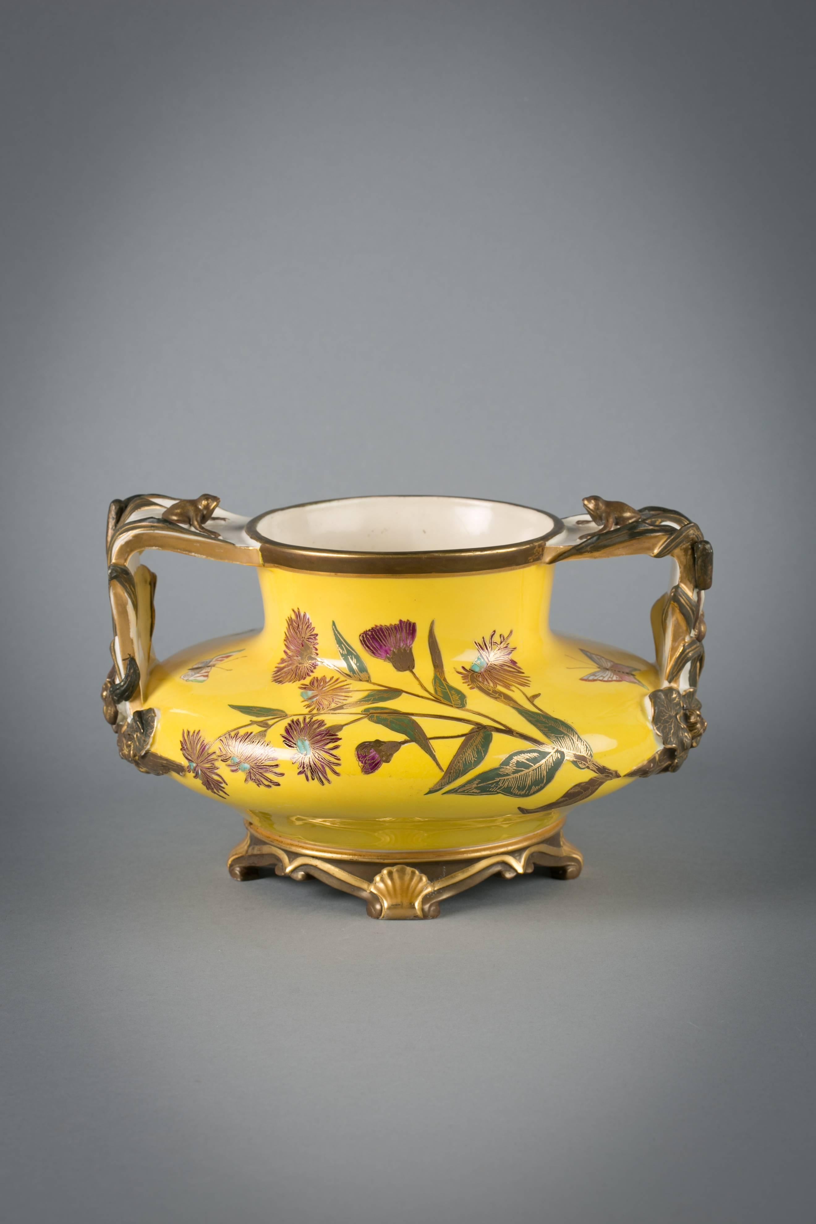 Vase Japonesque en porcelaine anglaise à fond jaune, Royal Worcester, daté de 1883

Chaque manche est orné de deux grenouilles, l'une grimpant sur le côté et l'autre étant assise au sommet du manche.