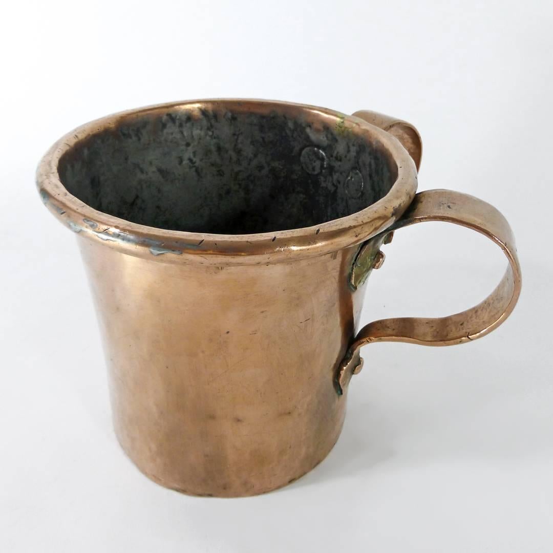 Russian two-handled copper wash cup, circa 1850.

Dovetailed. Judaic. Used for the ceremonial washing of hands (netilat yadayim).

Unusual features include thumb piece and scalloped detail.

Measures: Height 5 1/2?
Opening diameter 5