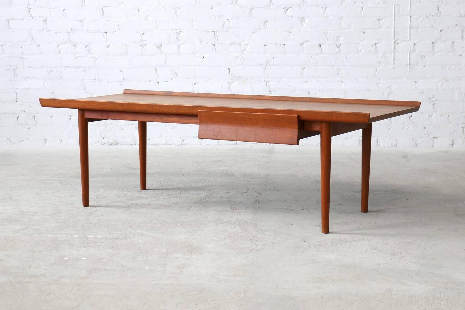 - very rare model
- designed Ca. 1954
- solid teak drawer
- solid teak frame 

A very rare teak coffee table by Finn Juhl for Niels Vodder. The raised lip and angled drawer give this piece it's modern flare. Also features a cantilevered table