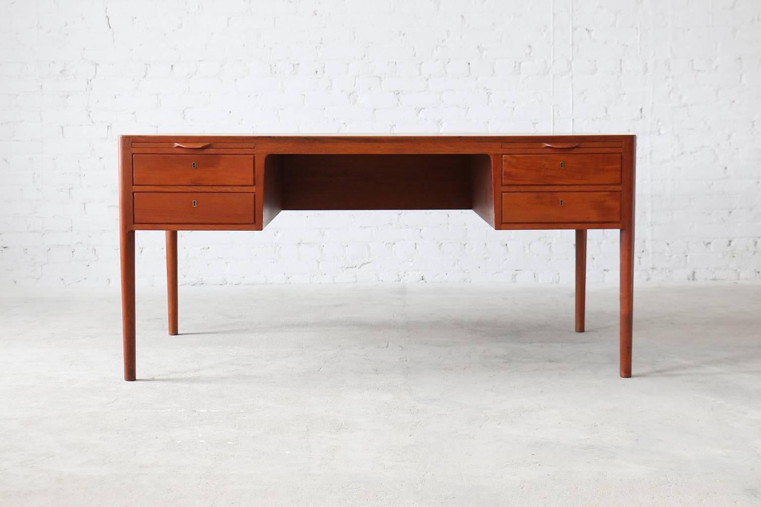 - solid teak frame and banding
- seldom seen design
- 4 locking drawers and two pull-out writing surfaces

A seldom seen teak desk by Hans Wegner for Johannes Hansen. This example has four locking drawers and two pull out writing surfaces which