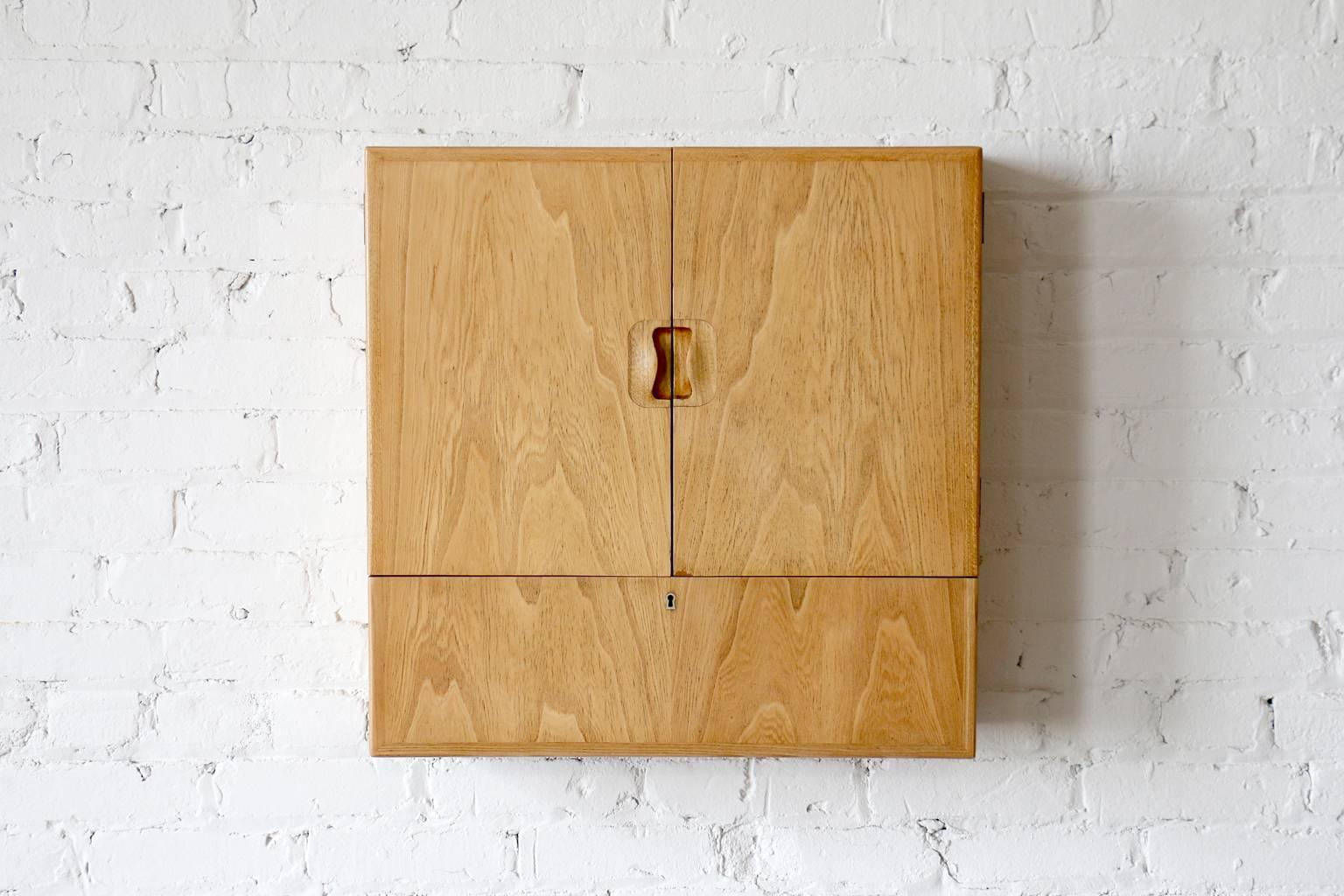 Model "Young Lady Wanted".
Rarely seen design.
Constructed of elm.
Designed in 1941.

A rarely seen wall cabinet by Tove & Edvard Kindt-Larsen for Gustav Bertelsen. This piece was cleverly named "Young Lady Wanted" and