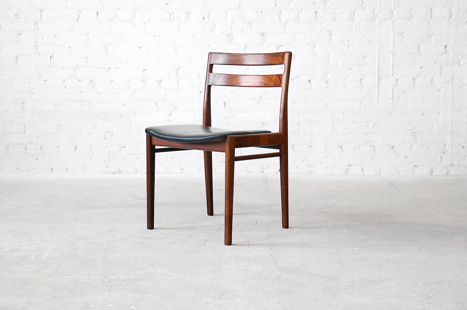 A set of eight impressive and elegant dining chairs designed by Henry Rosengren Hansen for Brande Møbelindusti. Solid rosewood frames are expertly joined. The unique hand-carved backrest is the highlight of the design.

- Designed, circa 1960
-