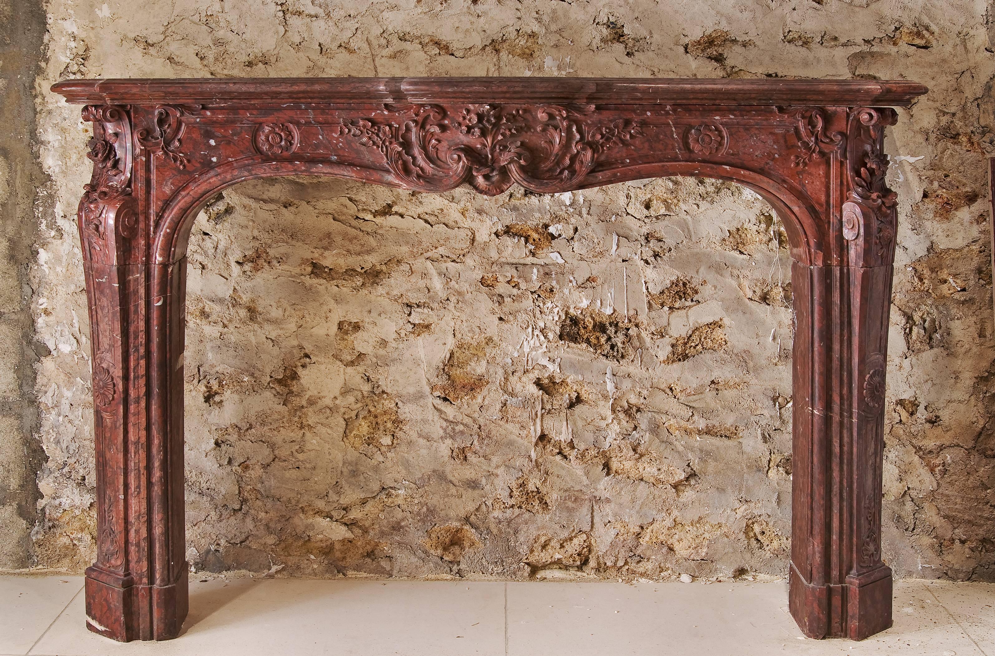 A beautiful Louis XV fireplace in Morello cherry marble from the French, mid-18th century.
This mantel is richly carved on its entire central frieze and again on both jambs with leaves and flowers decoration.
The jambs are sculpted on their whole