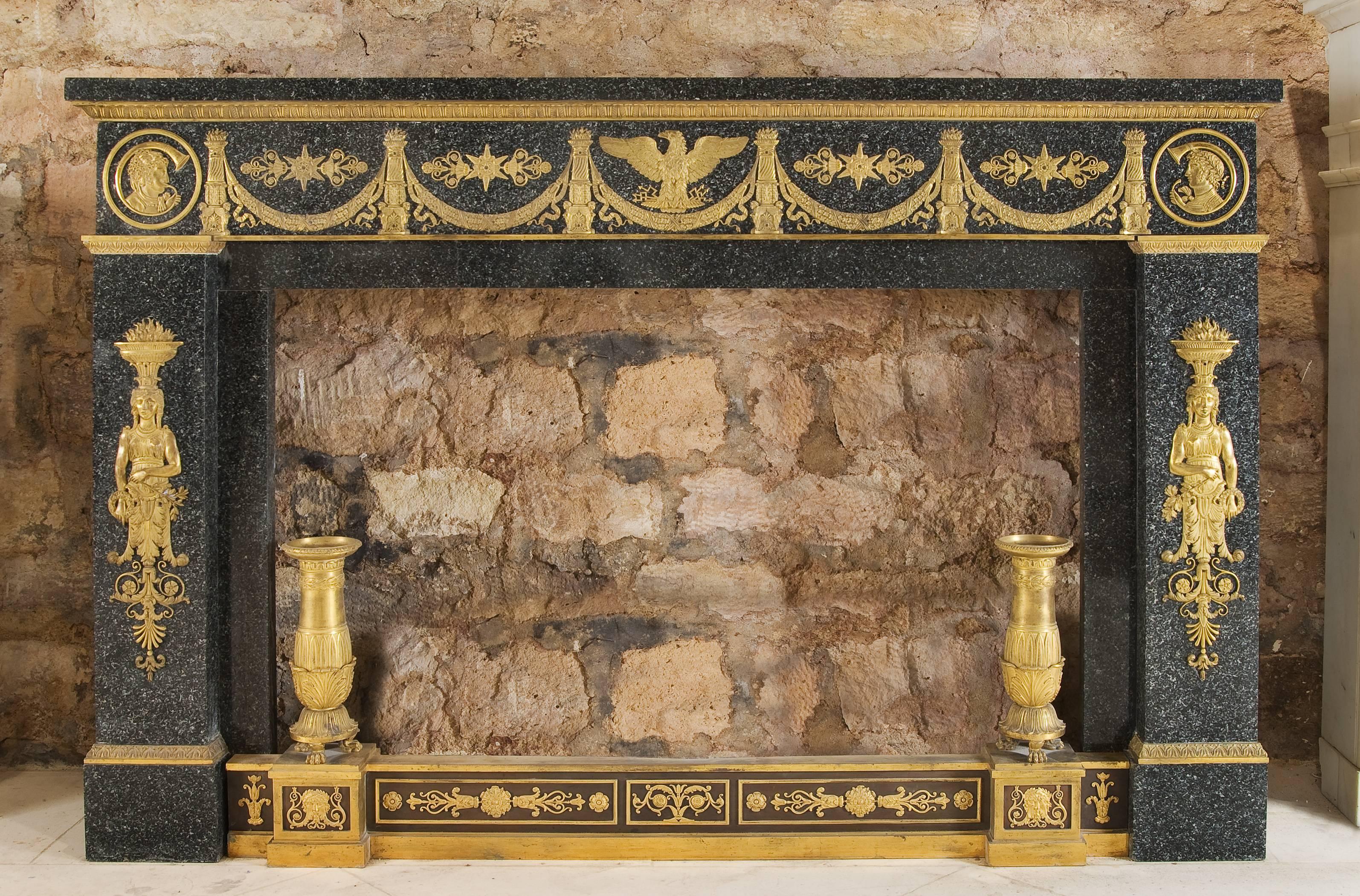 A grey marble fireplace with gilded bronze ornaments.
This mantel is dated from the early 19th century.
Twined with the one at the German Embassy rue de Lille in Paris, France.
A typical Empire style decoration with eagles, stars, flower garlands