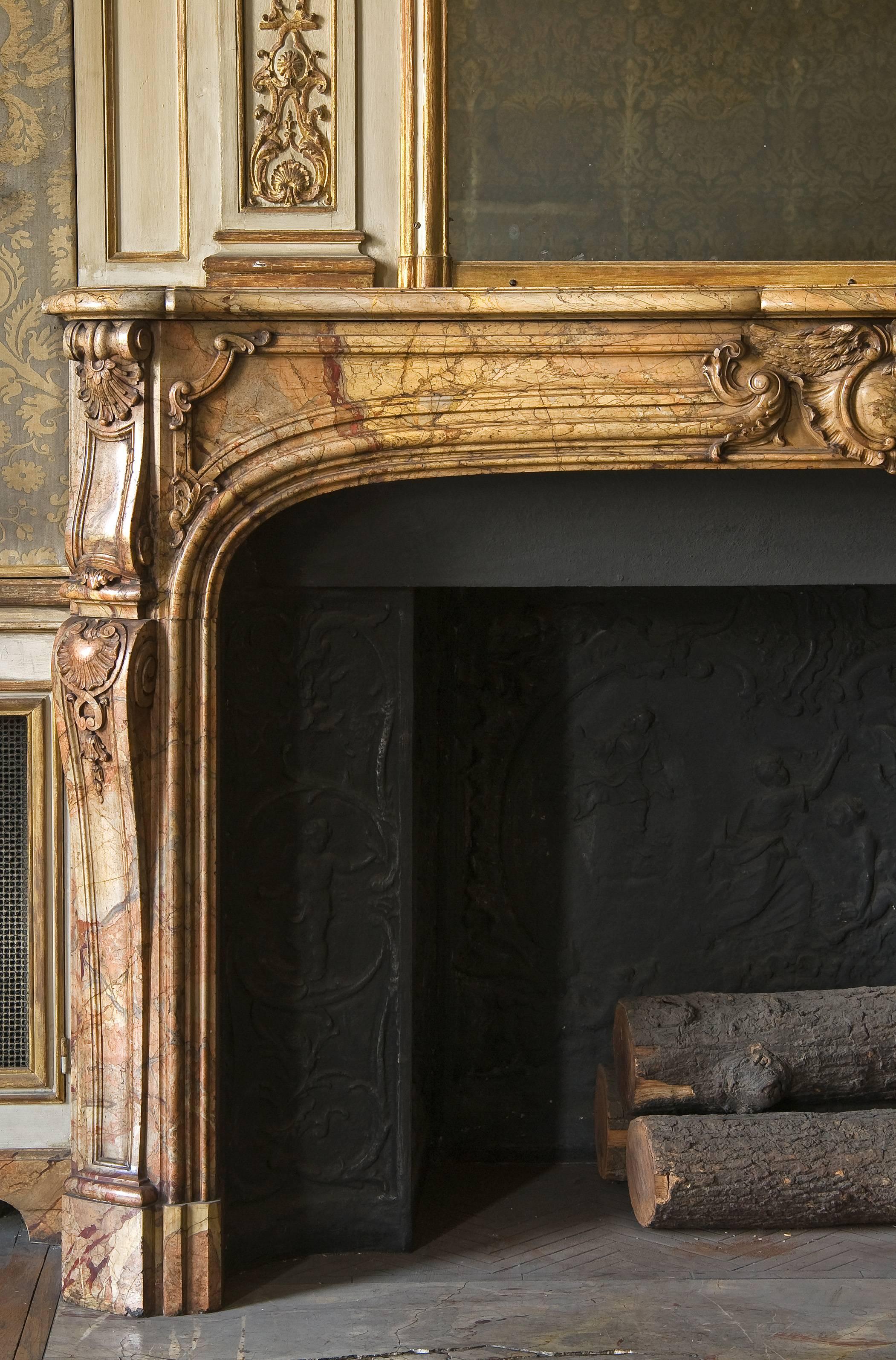 This fireplace is in Saracolin, the marble is carved on the shelve and jambs.
The firplace is sold with its irons.
Origin: Lesieur Collection, Paris avenue Foch.
 