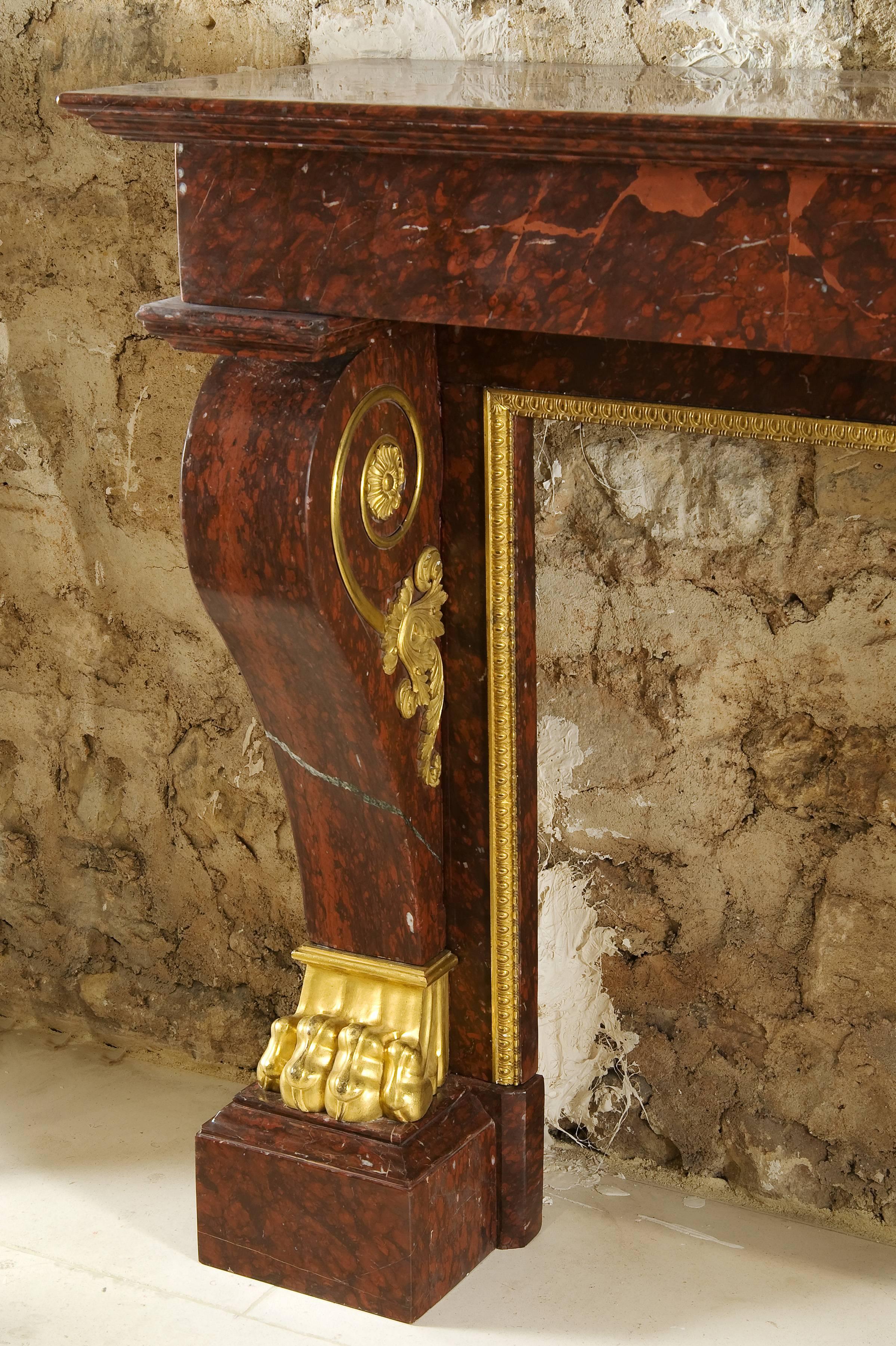 Beautiful fireplace in red marble with gilded bronze ornaments, this fireplace decoration is said "with Tiger paws."