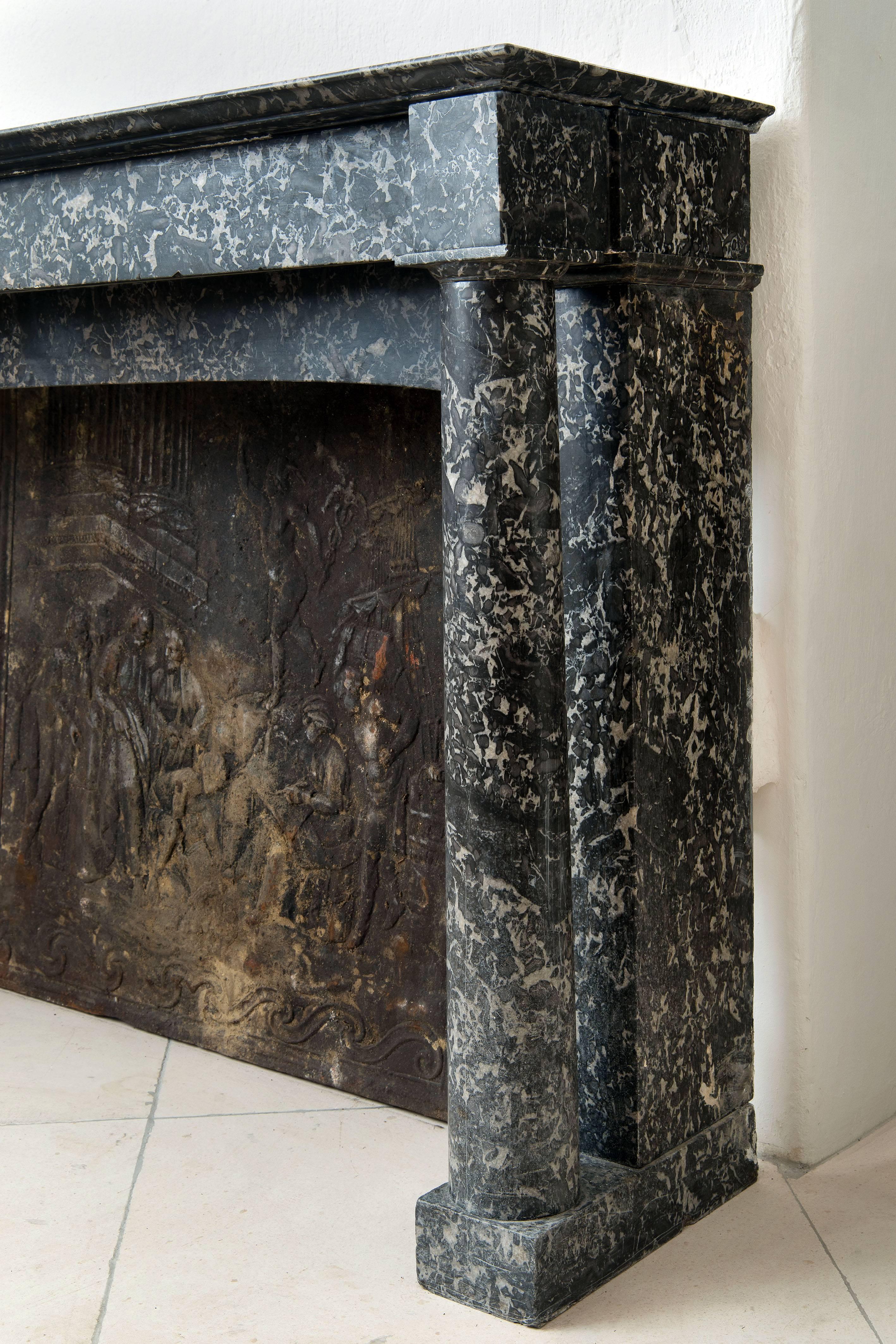 Beautiful fireplace in grey marble with columns.