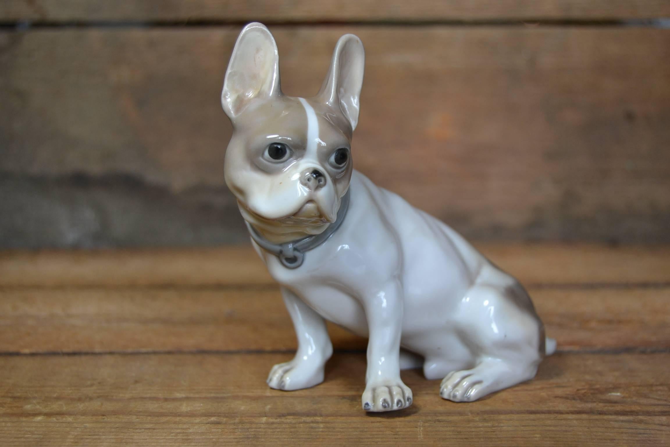 Art Deco Porcelain Bulldog Figurine made by the Goebel Company, Germany.
This Seated Dog Figurine has the colors white and soft brown and has a grey-blue Collar. This German Porcelain is Double Crown Stamped and  engraved : CH 191  . This stamp was