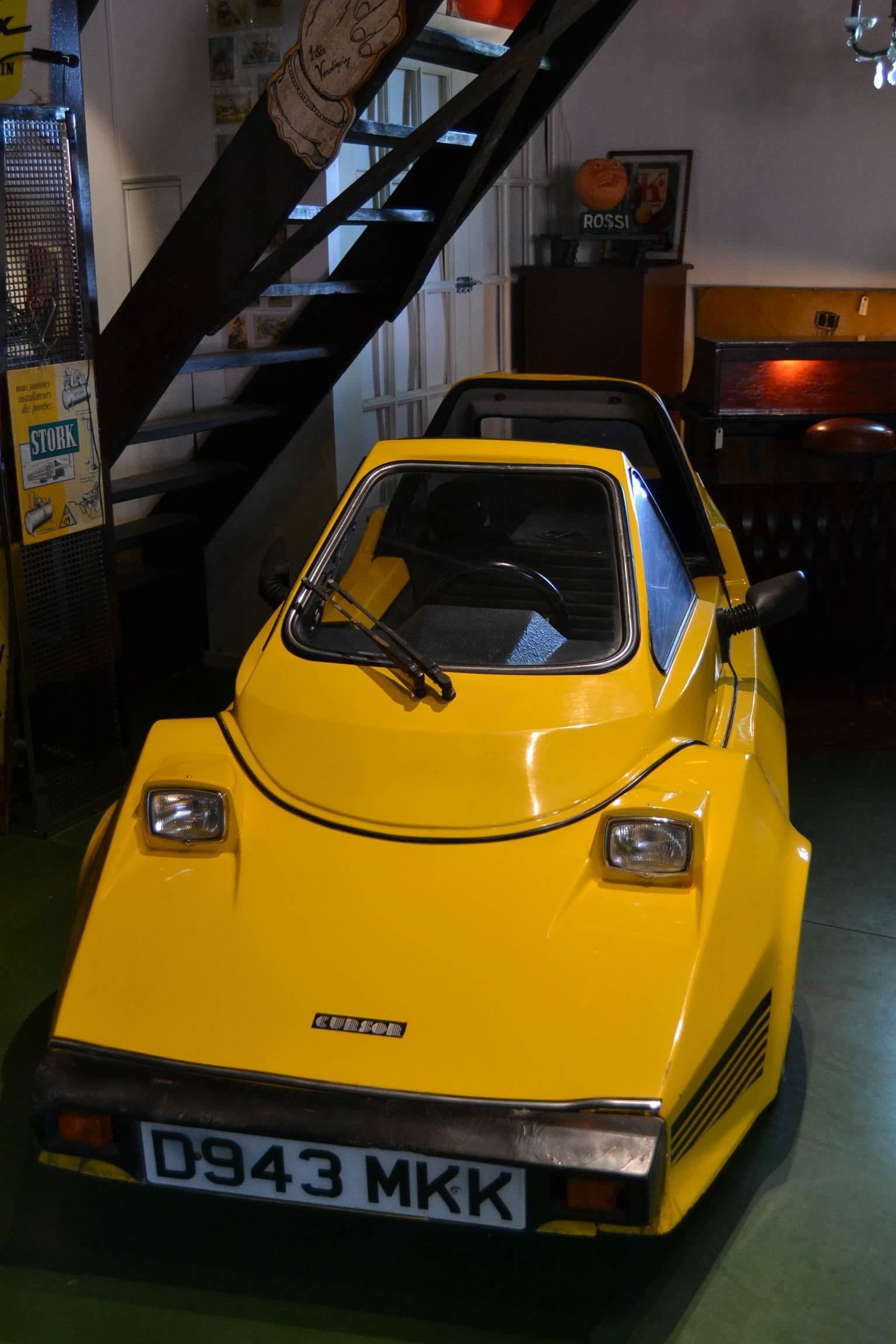 Cursor microcar bubblecar tricycle.
Designed by Alan Hatswell to fit moped regulations in the UK.
Made by Replicar Limited, UK (Kent) 1985-1987.
Production: 100 pieces worldwide.

Re-enforced fibreglass body on tubular steel chassis.
Electric