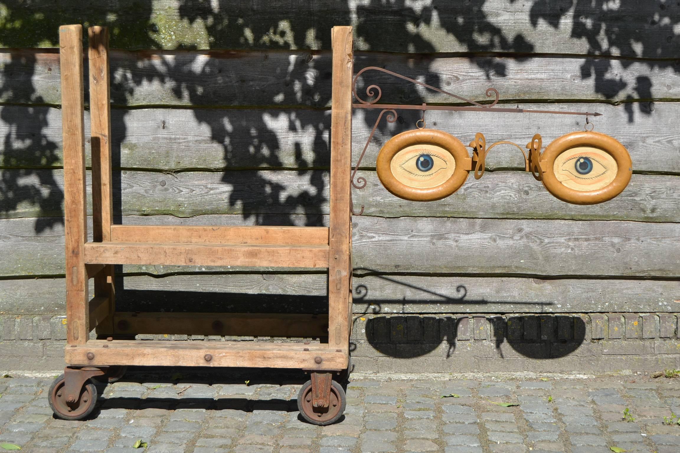 Antique hanging advertising sign for doctor or optician, circa 1920-1930. Double sided big cast zinc glasses with four hand-painted eyes on original adjustable iron wall bracket. Collectable item - wall decoration - interior design -