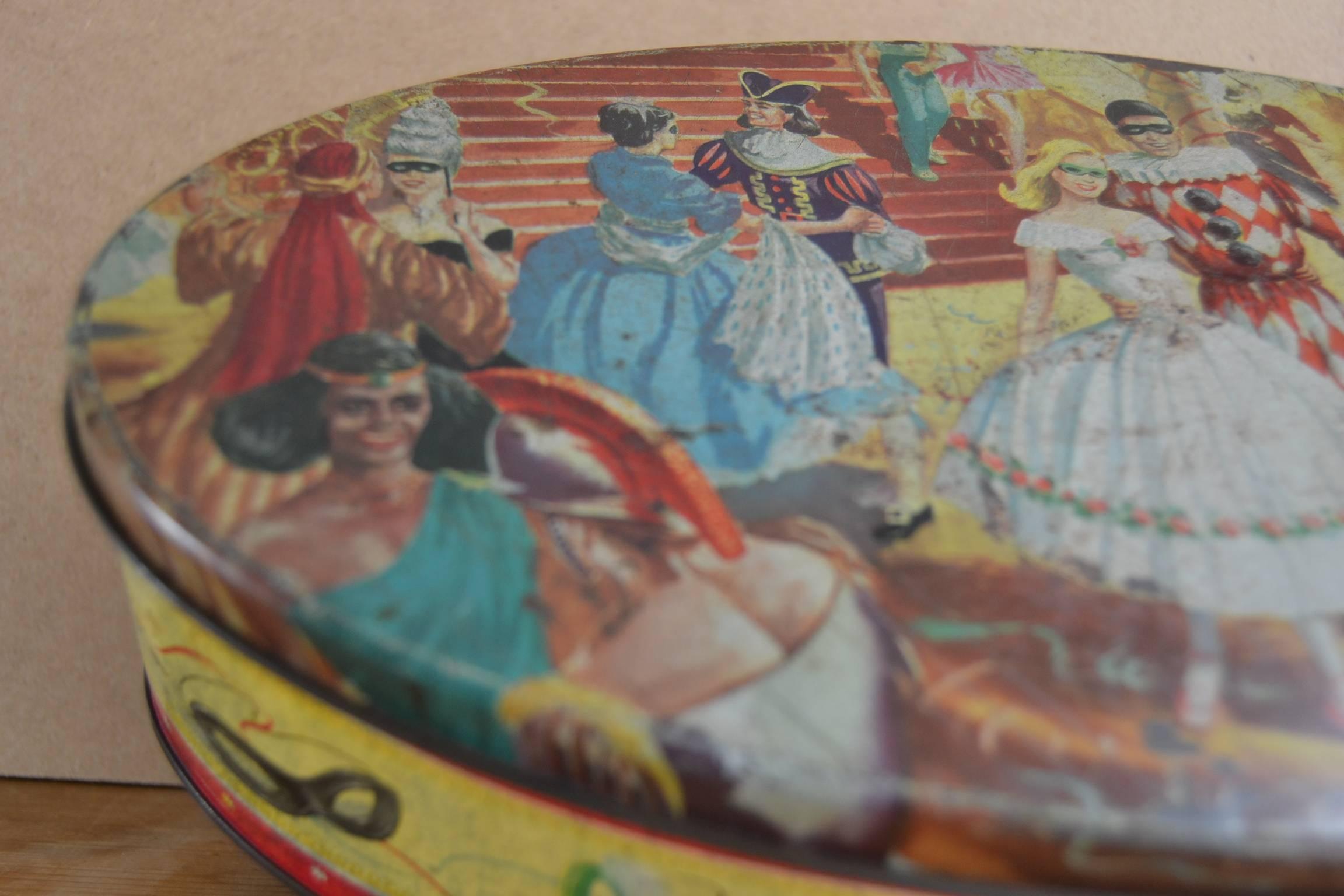 Oval Biscuit Tin with Masquerade Ball. This Biscuit Cookie Tin was designed for Peek Frean and co. Ltd - England circa 1940 -1950. 
This Lithographic English Tin has a great theme : 
The Masquerade Ball - Costume Party - Harlequin.

Oval Tin -